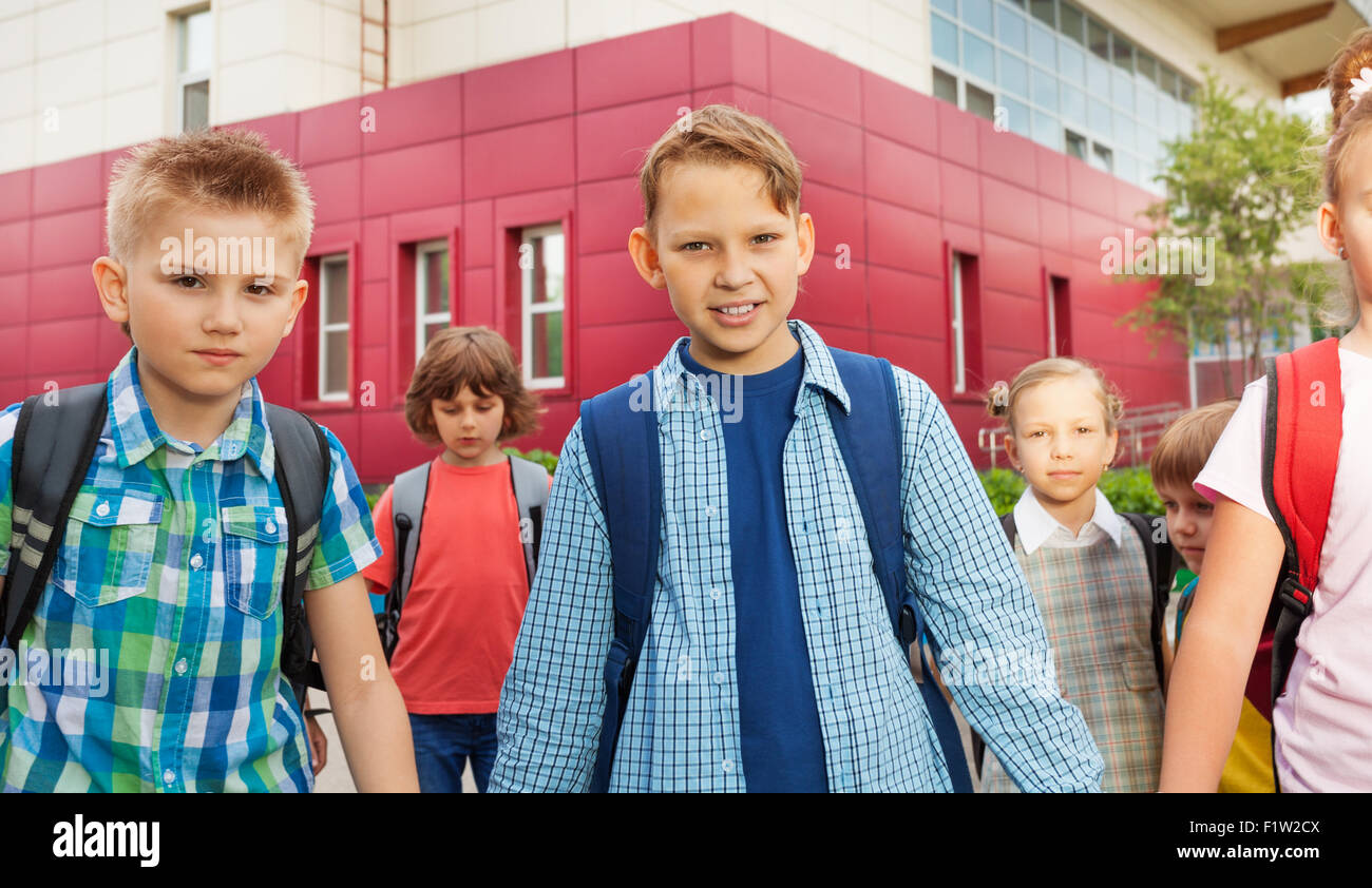 Les enfants portent des sacs à dos et à pied près de l'école Banque D'Images