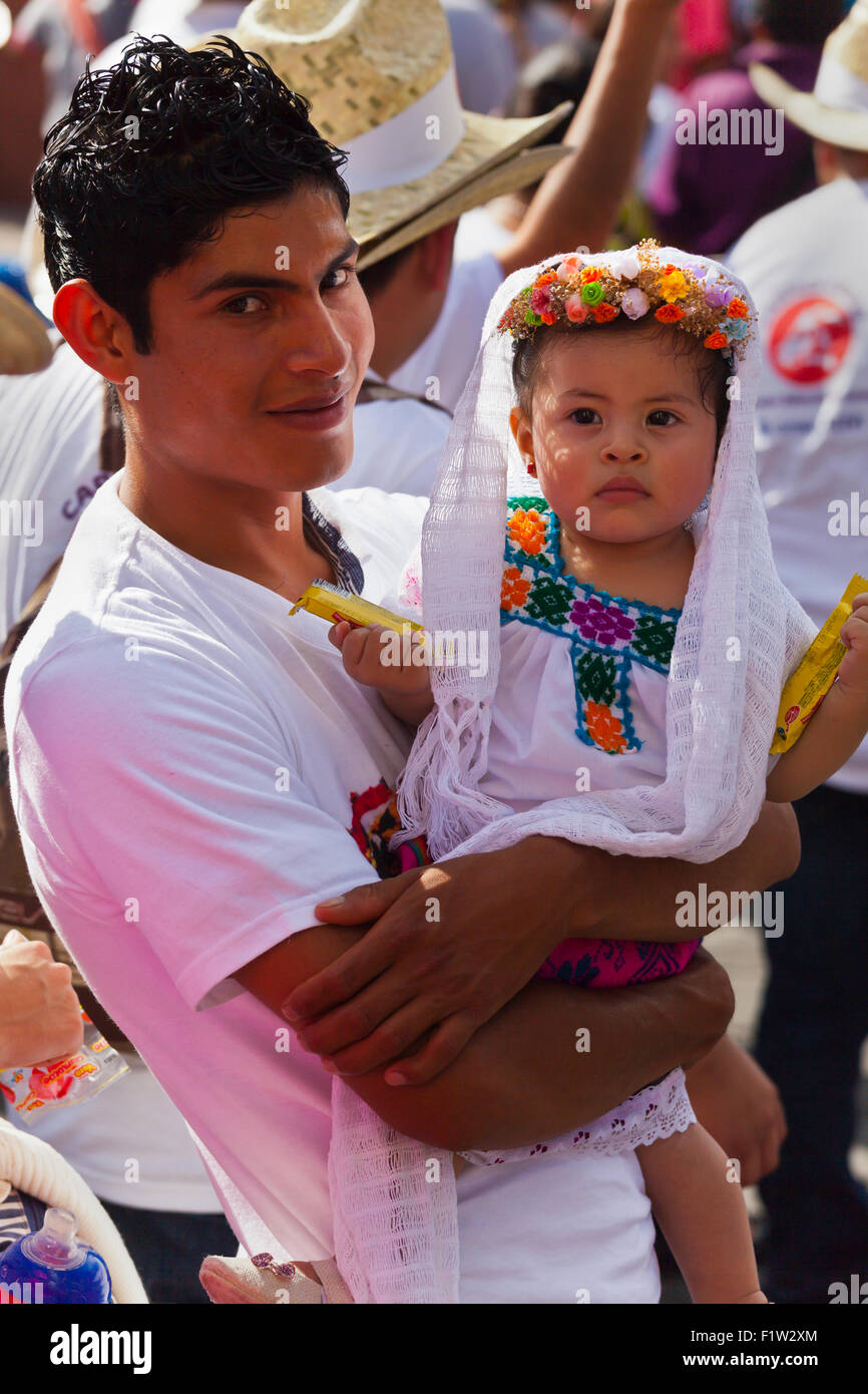 Un père de famille mexicain et bébé habillé de façon traditionnelle dans un défilé pendant le festival GUELAGUETZA Juillet - Oaxaca, Mexique Banque D'Images