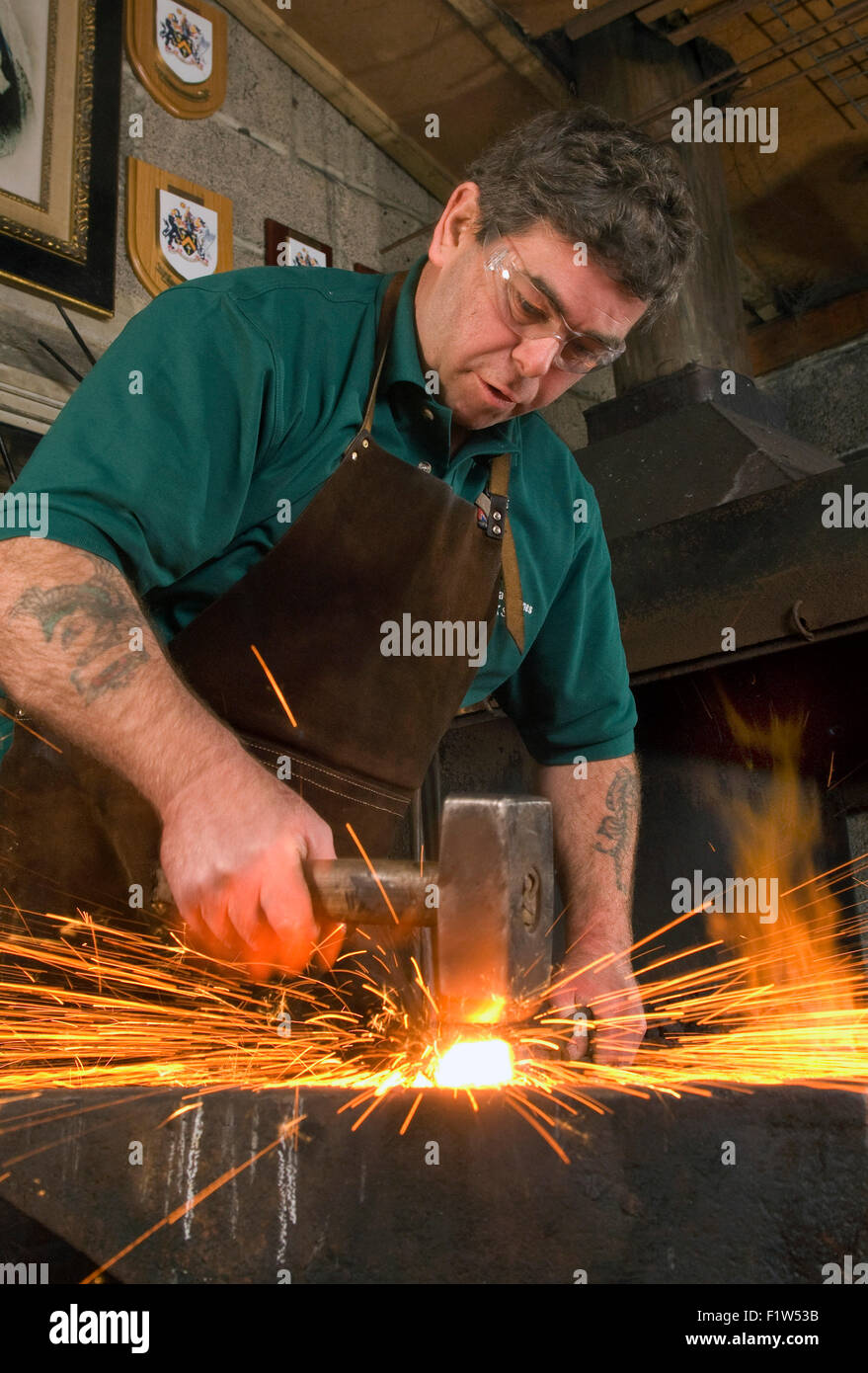 Grant-Jones Simon forgeron martelant le métal chaud avec étincelle,,dans sa forge, où il est un artisan métallier.Un UK Banque D'Images