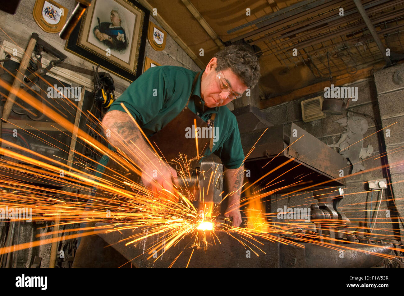 Grant-Jones Simon forgeron martelant le métal chaud avec étincelle,,dans sa forge, où il est un artisan métallier.Un UK Banque D'Images