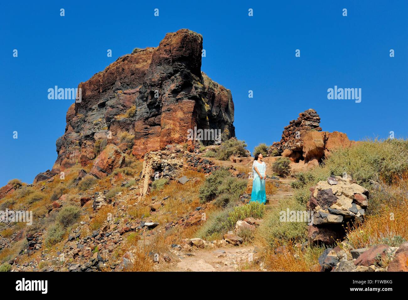 Un touriste posant pour une photo de Skaros rock,Santorini Grèce Banque D'Images