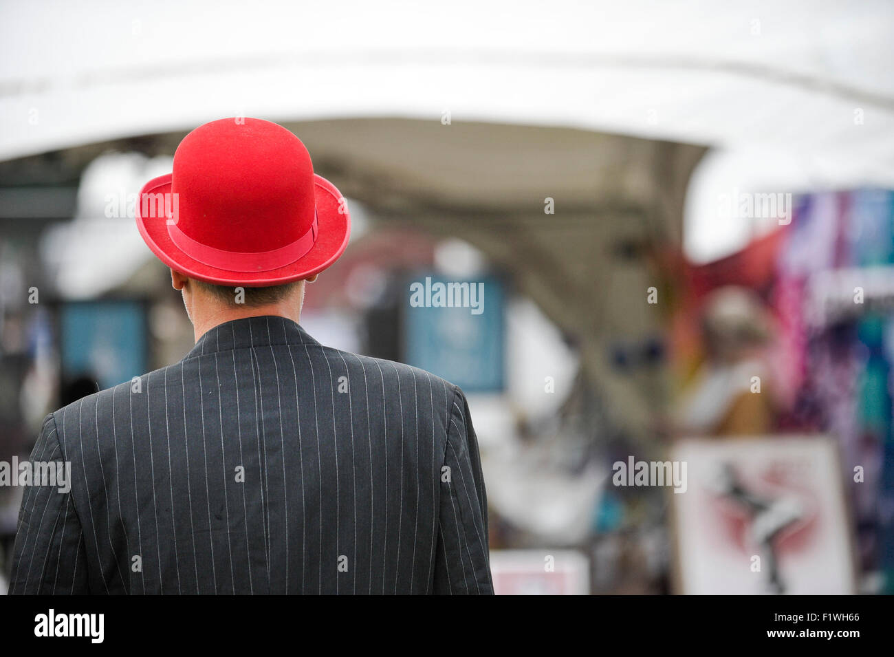 Un homme portant un chapeau melon rouge vif. Banque D'Images