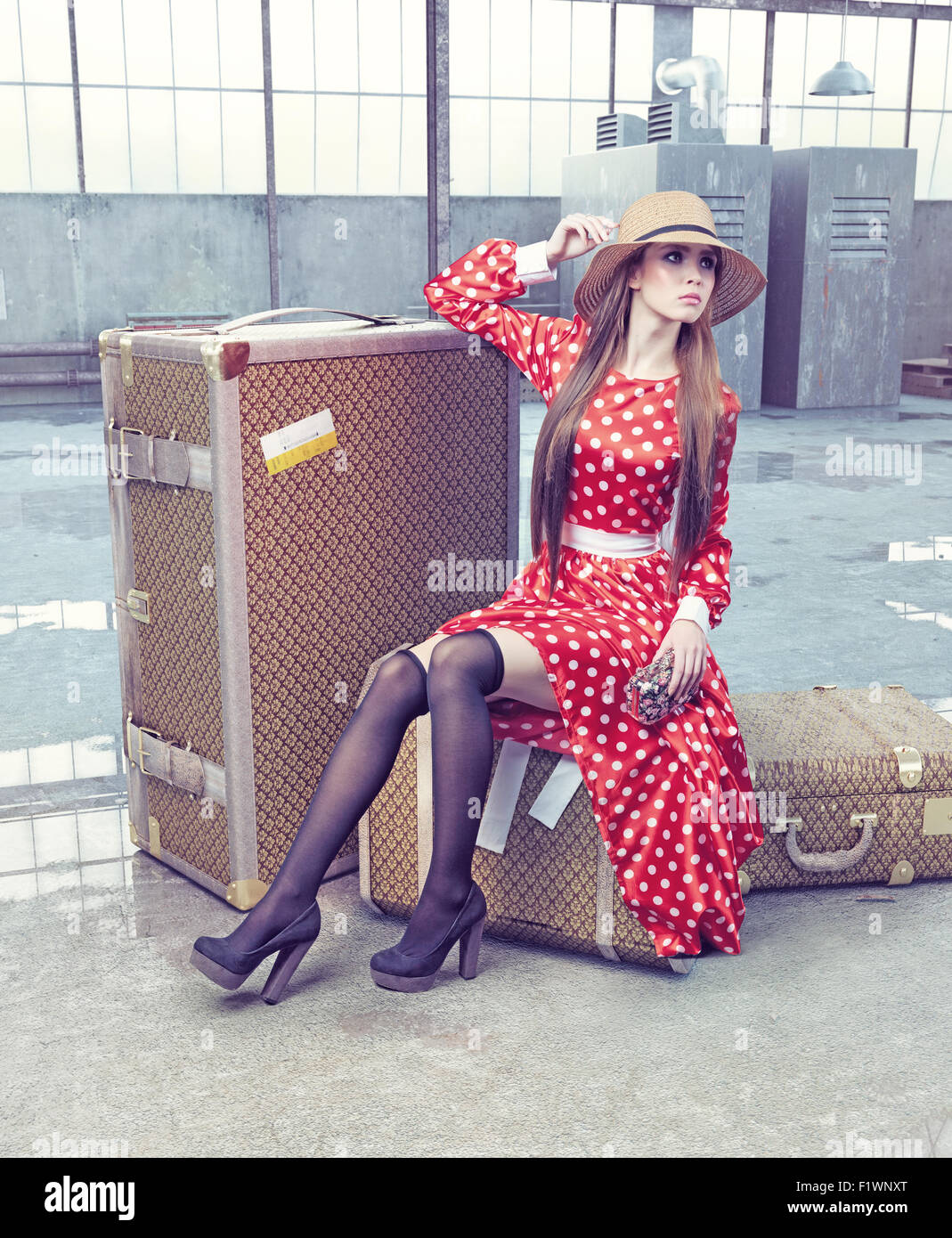 Fille assise sur une valise de voyage en attente Banque D'Images