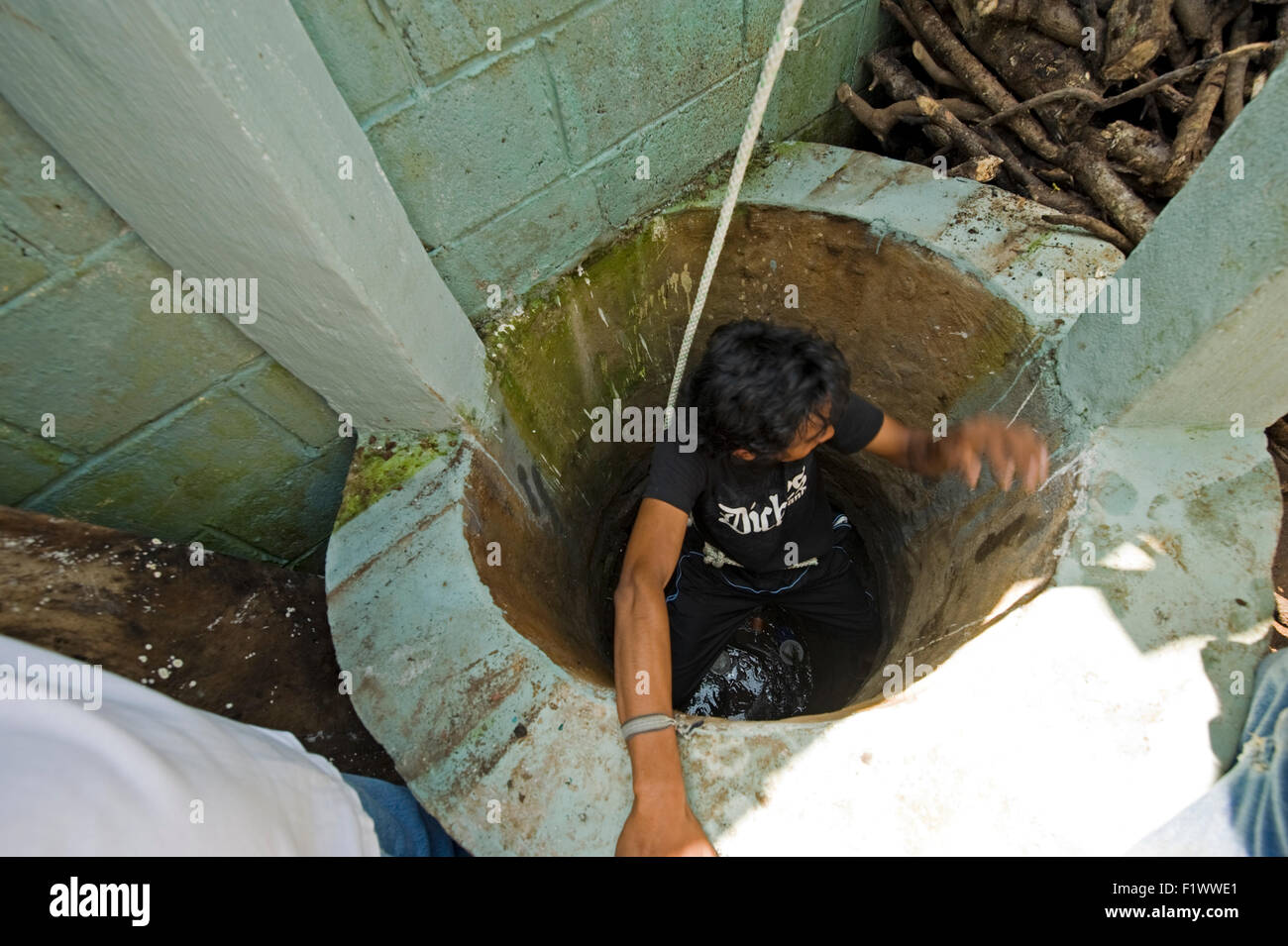 Guatemala, Retalhuleu, processus de nettoyage de l'école bien avec l'homme (Cristian Estuardo Lopez 15) passe dans le puits Banque D'Images