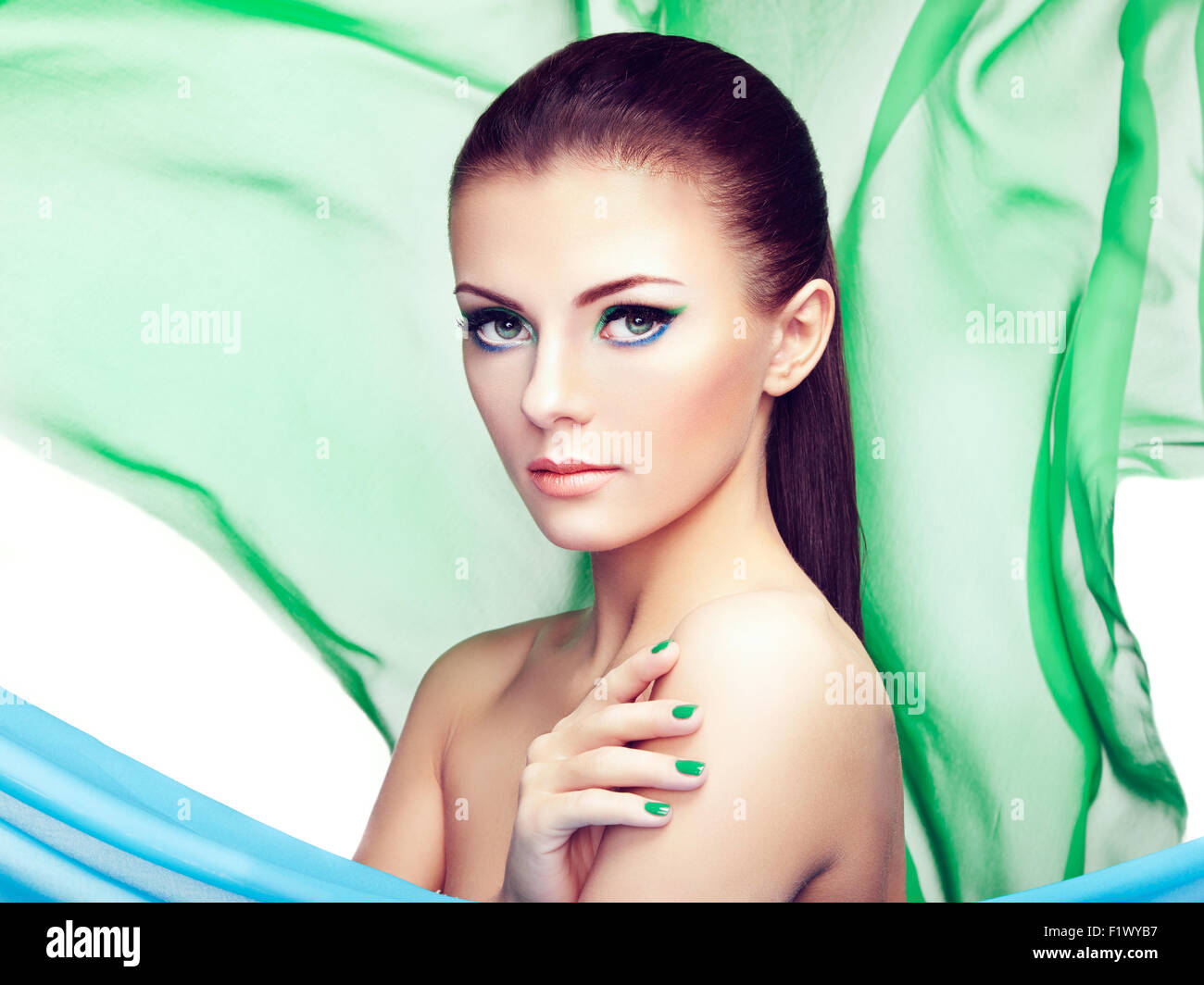 Portrait de jeune femme belle contre les projections de tissu. Beauty woman face closeup. Maquillage professionnel Banque D'Images