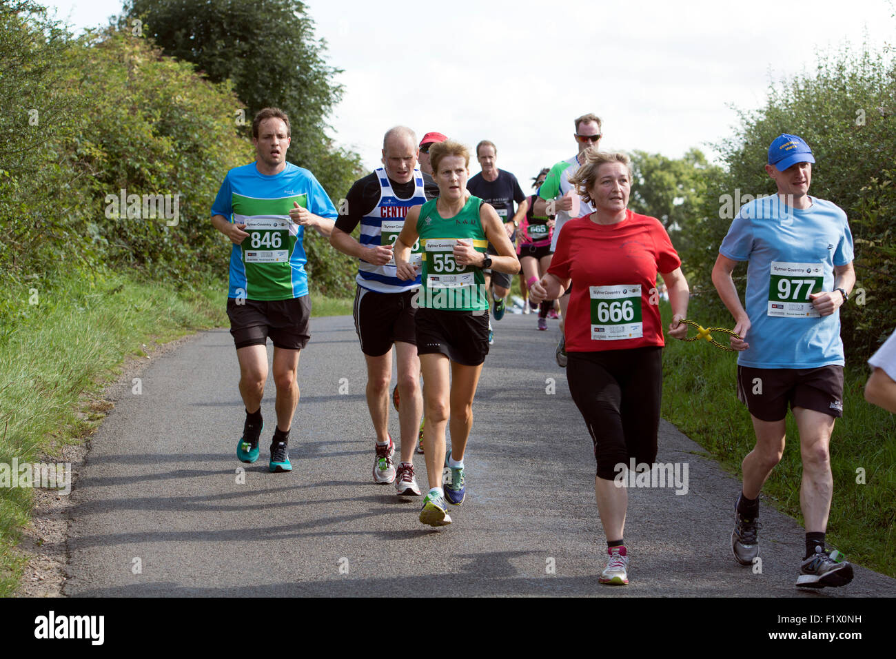 Demi-marathon coureurs sur une route de campagne, dans le Warwickshire, Royaume-Uni Banque D'Images