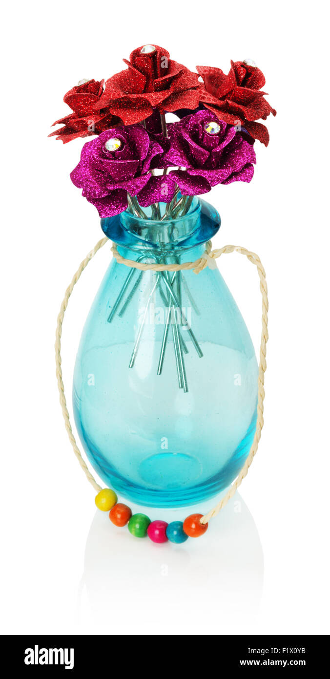 Roses artificielles dans un vase de verre isolé sur le fond blanc. Banque D'Images