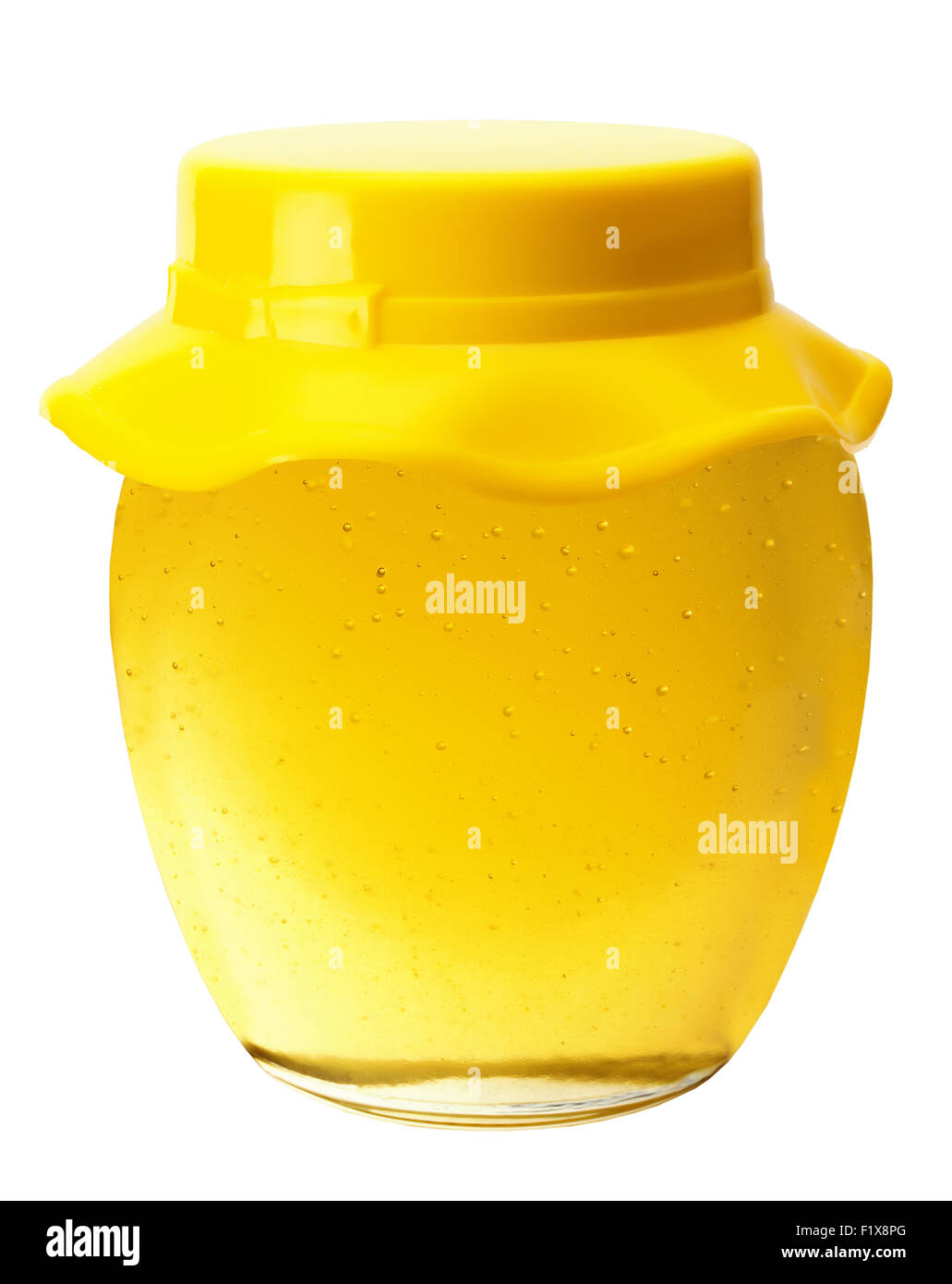Pot de miel doré isolé sur le fond blanc. Banque D'Images