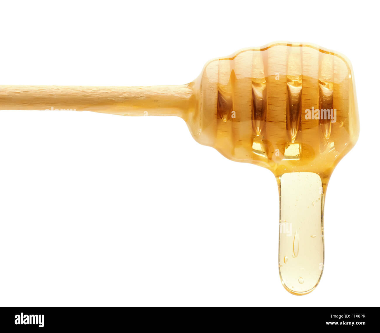 Le miel des gouttes d'un balancier de miel en bois isolé sur le fond blanc. Banque D'Images