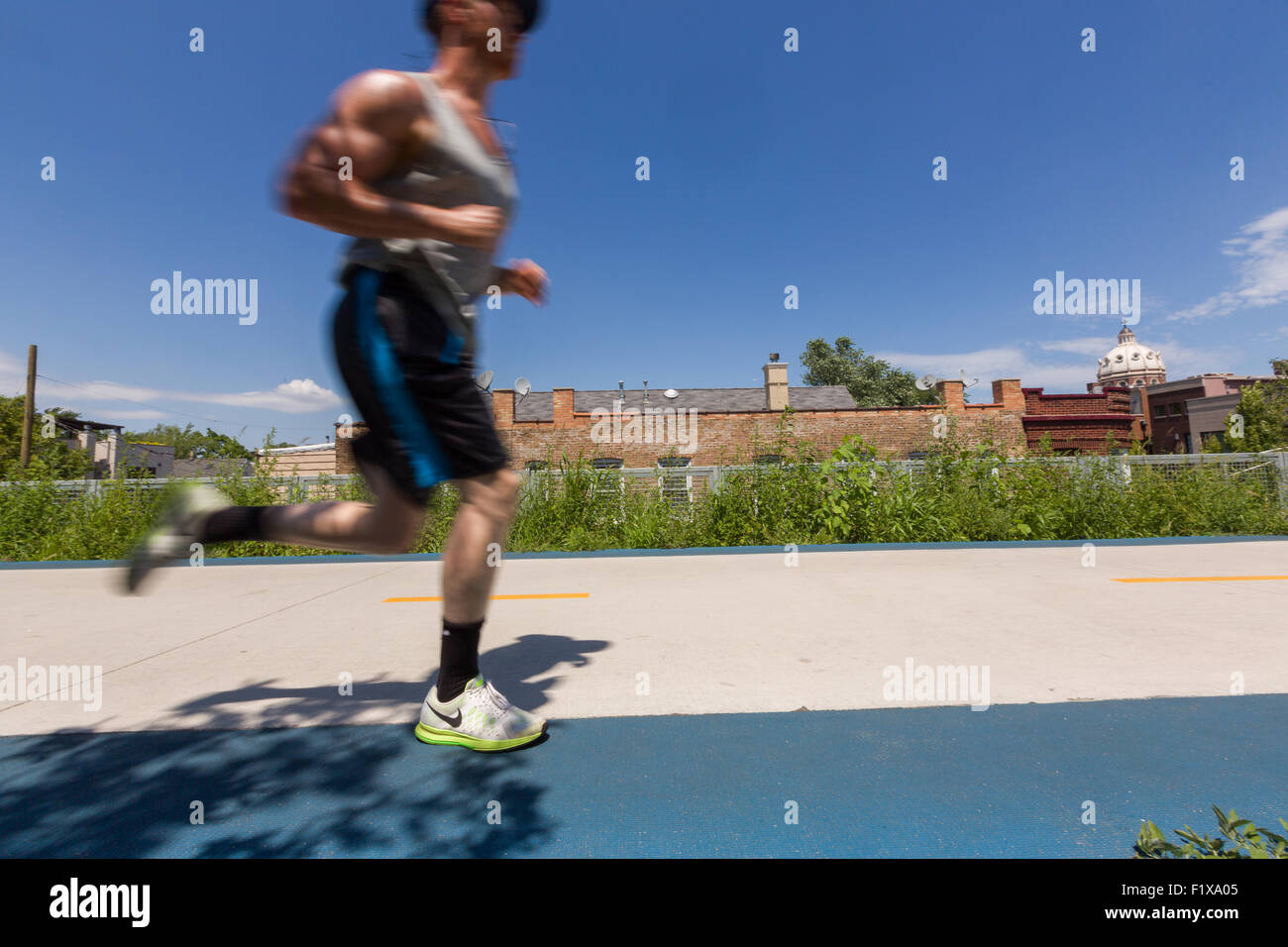 Un coureur sur la piste cyclable surélevée 606, l'espace vert et parc construit sur l'ancienne ligne de Bloomingdale dans le Logan Square près de Chicago, Illinois, États-Unis Banque D'Images