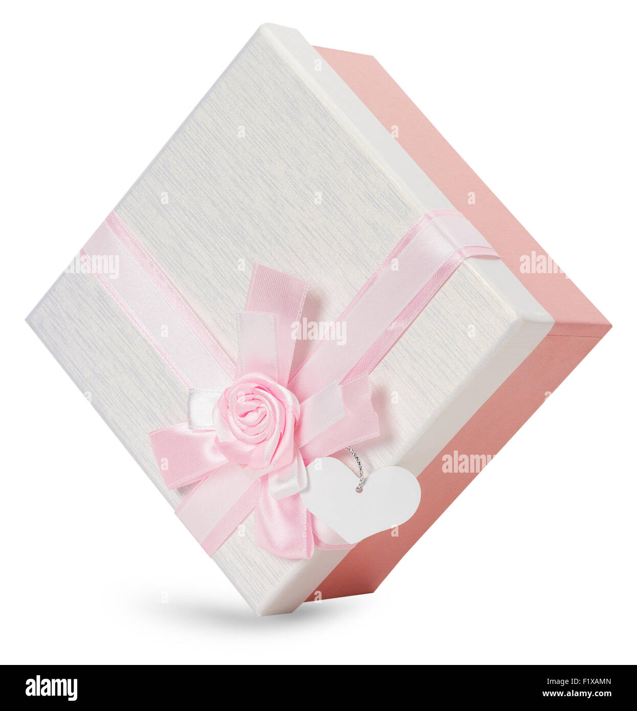 Boîte-cadeau avec noeud rose isolé sur le fond blanc. Banque D'Images