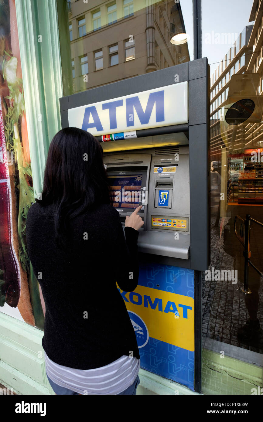 Jeune femme à l'aide d'un guichet automatique pour retirer de l'argent Banque D'Images