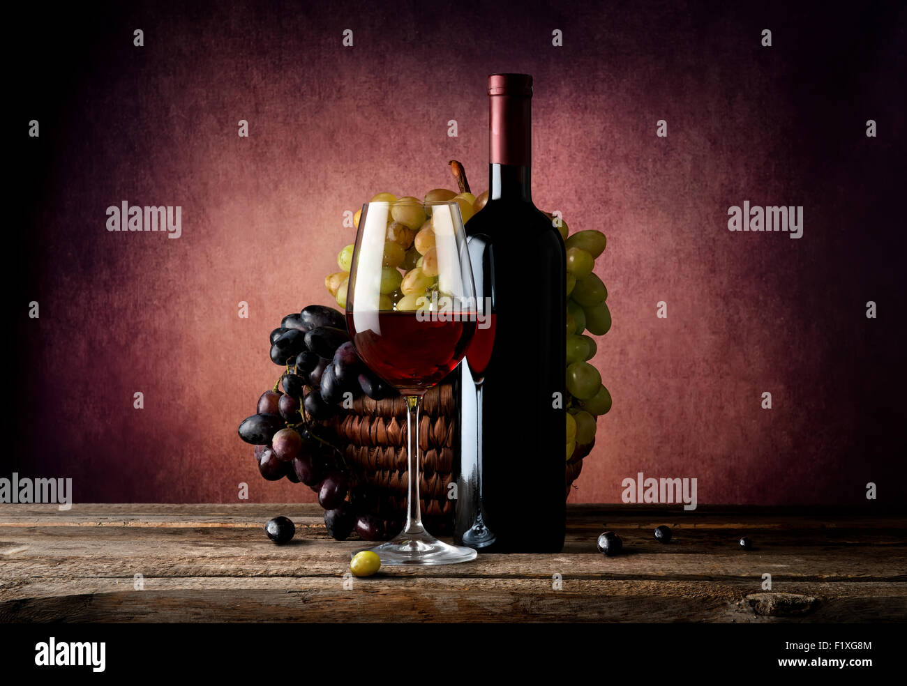 Vin rouge avec panier de raisin sur la table Banque D'Images