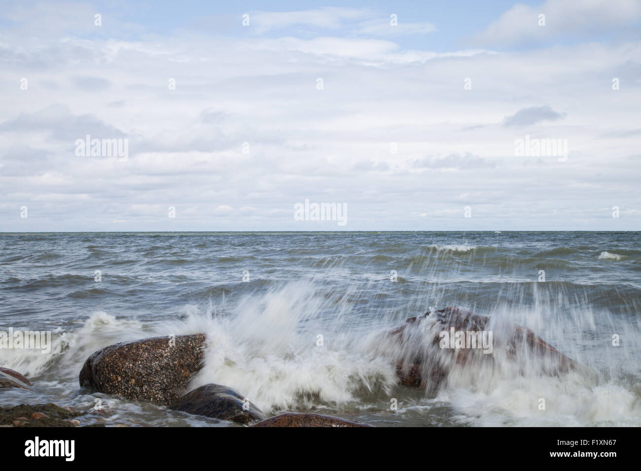 Les vagues se brisant sur des pierres et spray Banque D'Images