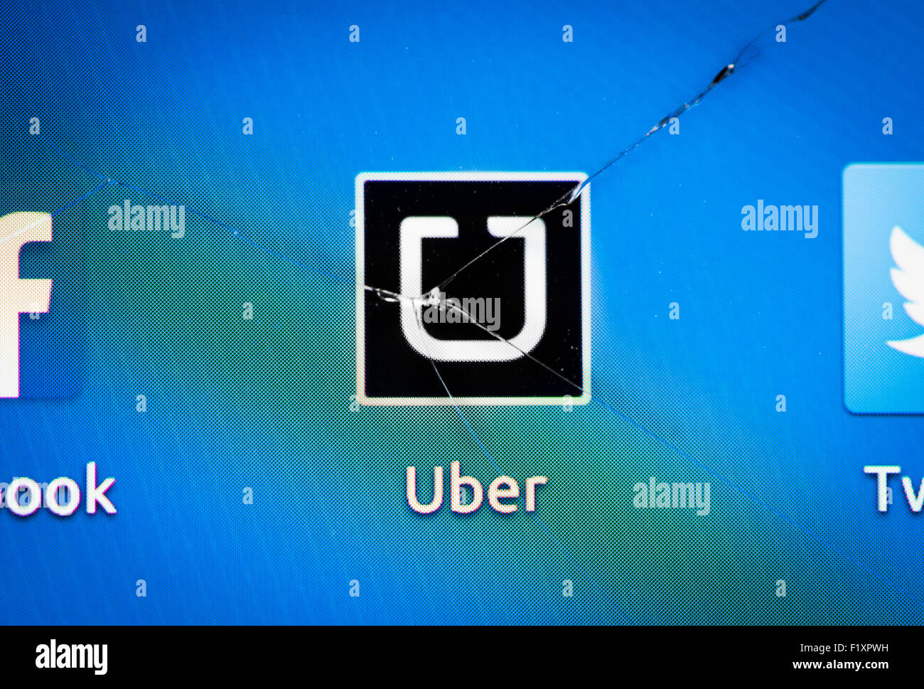 L'icône de l'application de service de taxi Uber est affiché sur un smartphone à l'origine d'une grande fissure dans le verre de l'écran tactile. Banque D'Images