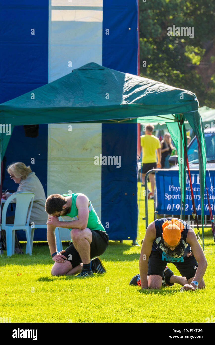 Deux coureurs sur leurs genoux redressent après la 10k run à l'Wolverhampton UK Marathon sculpteurs liens sponsorisés Banque D'Images