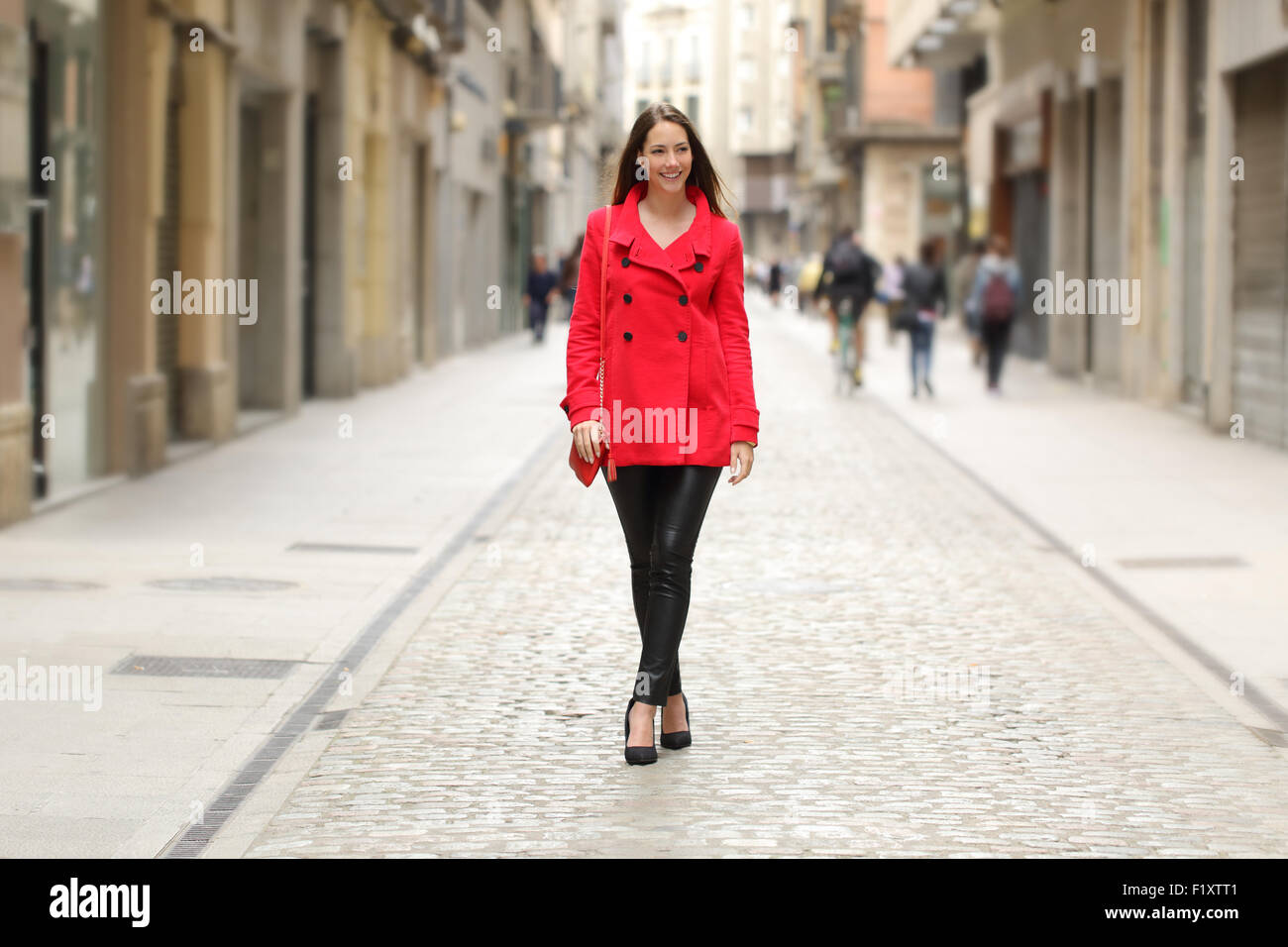 Happy fashion woman in red marche sur une rue de ville en hiver Banque D'Images