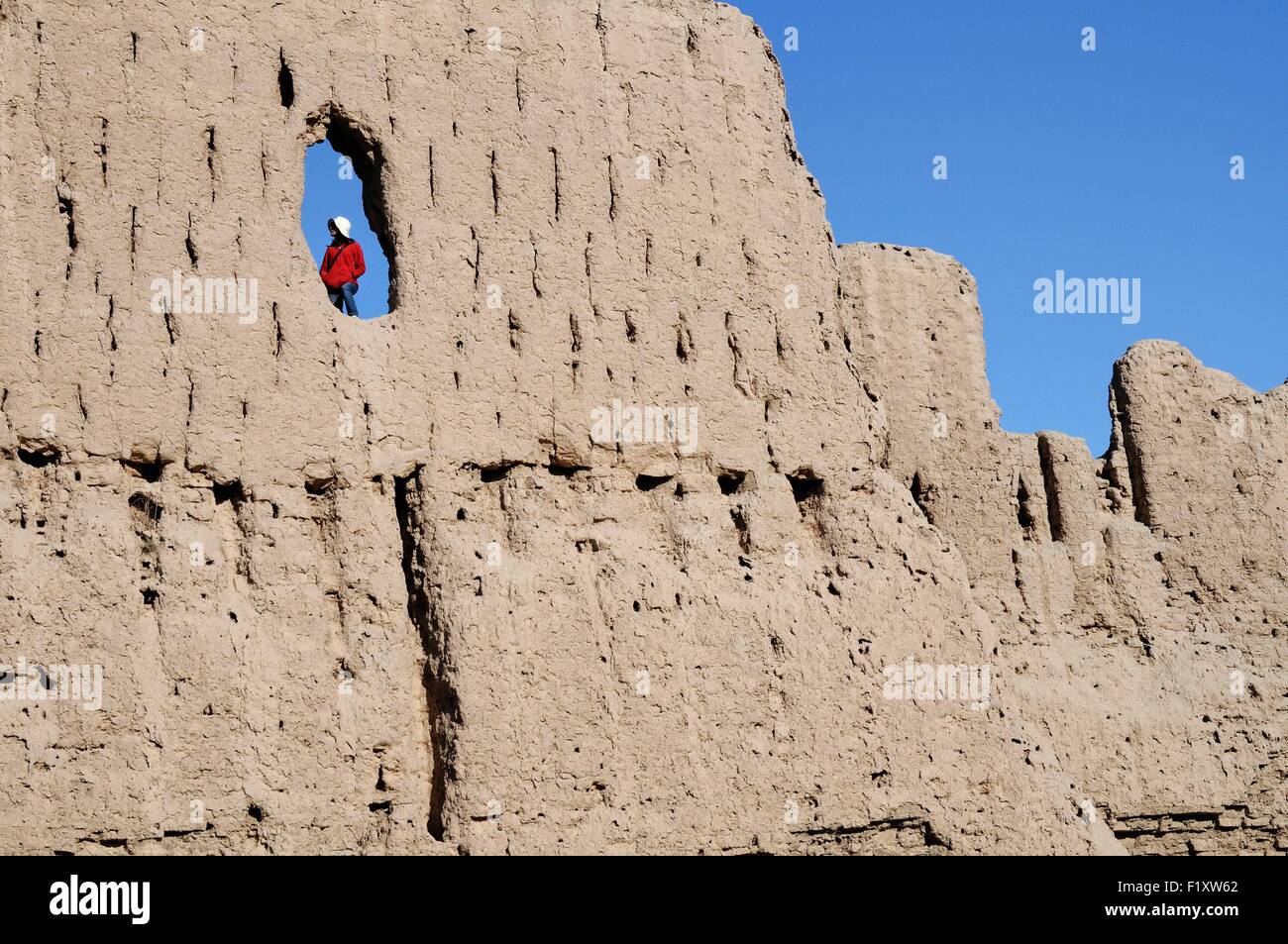 L'Ouzbékistan, Karakalpakstan, femme dans un trou dans un mur de Qyzyl Qala forteresse du désert Banque D'Images