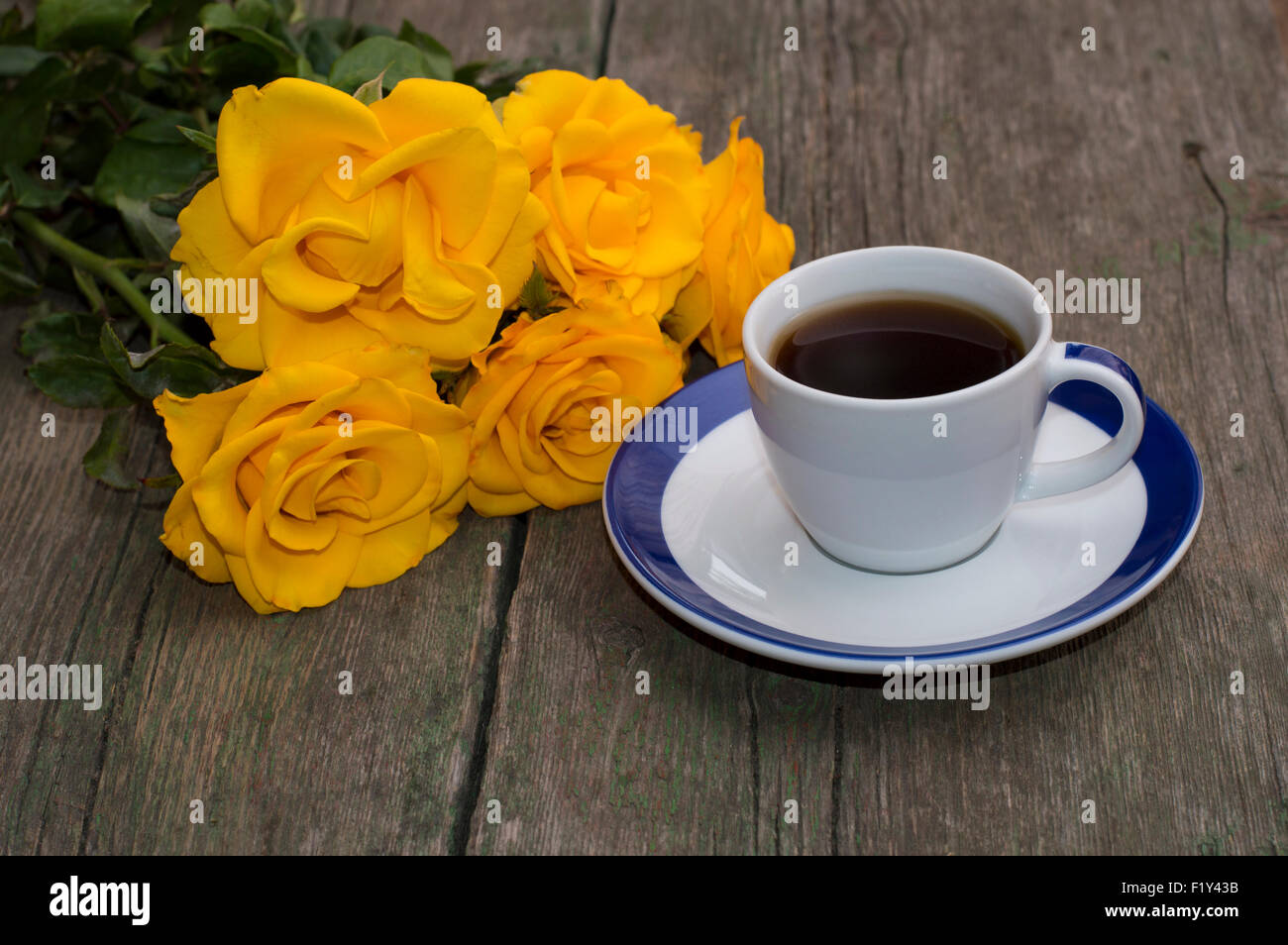 Bouquet de belles roses et tasse de café sur une table minable Banque D'Images