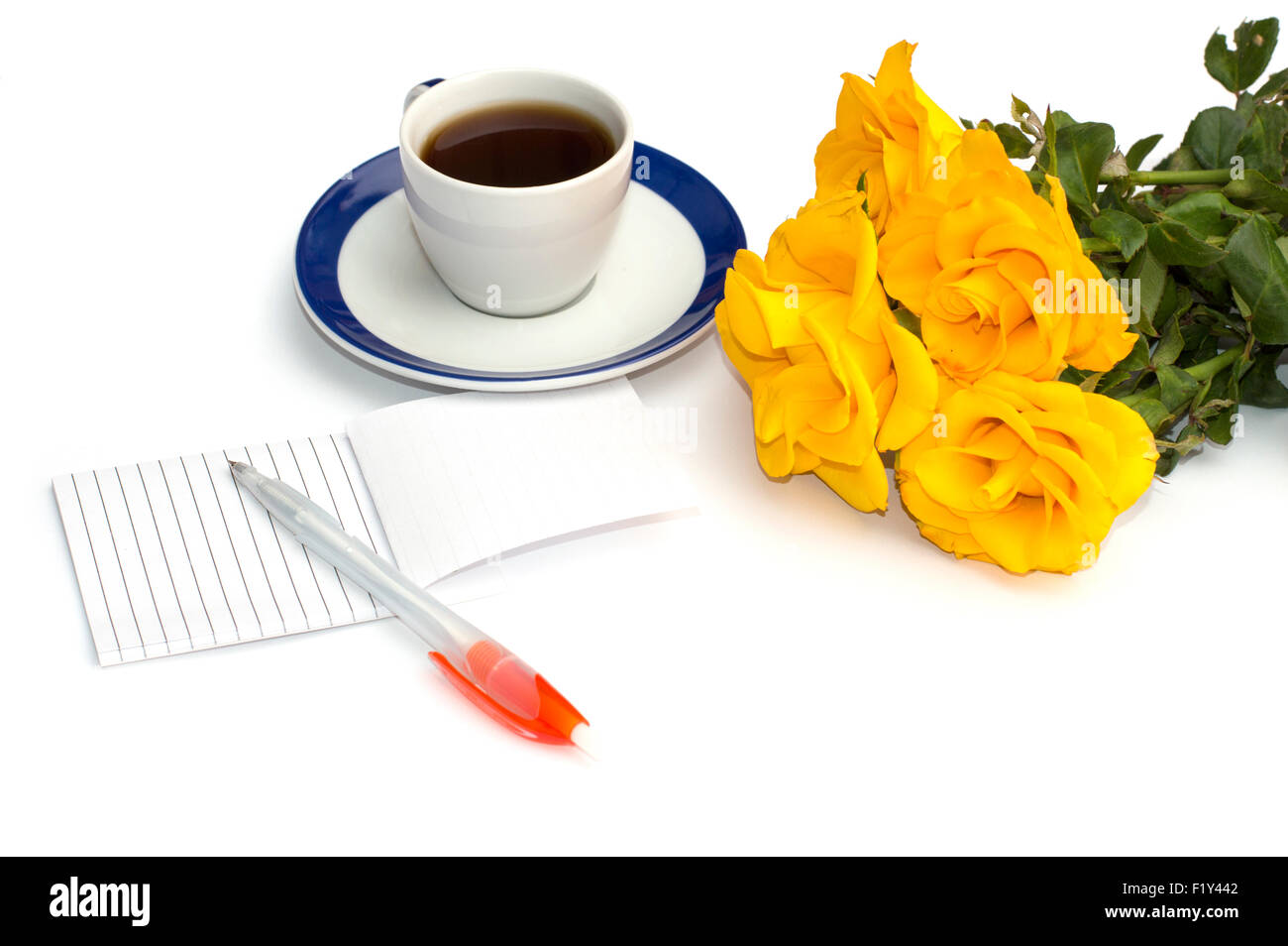 Tasse de café, ordinateur portable avec la poignée et un bouquet de roses jaunes Banque D'Images