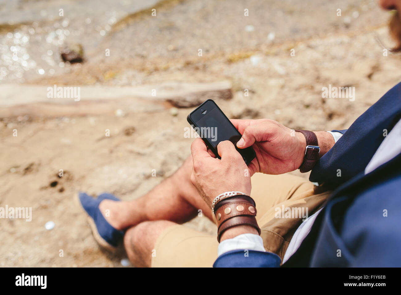 Homme barbu américain à l'aide de téléphone près de la rivière Banque D'Images