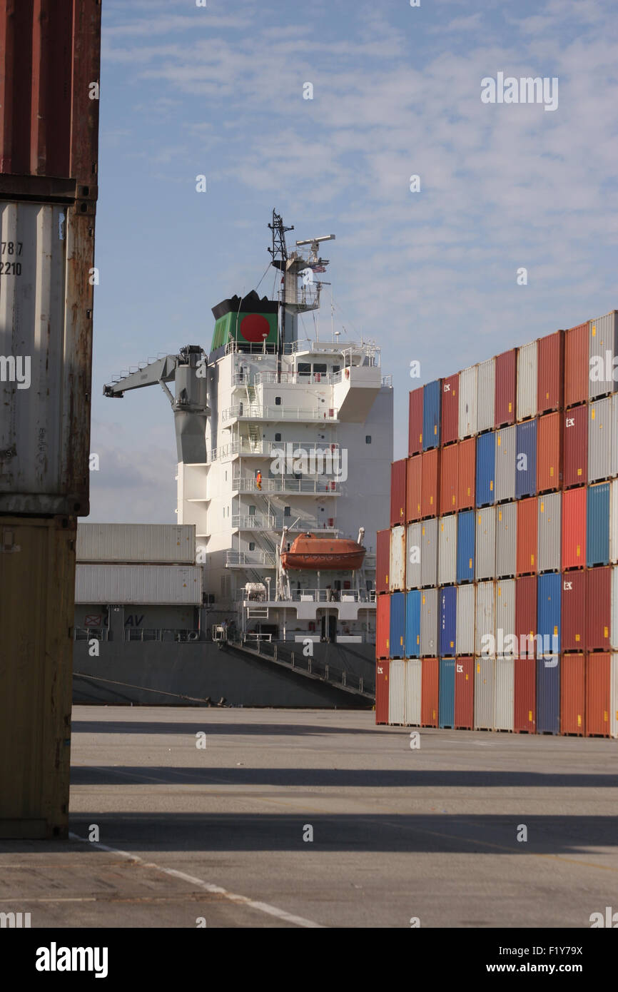 Des conteneurs empilés et container bateau amarré au port Banque D'Images