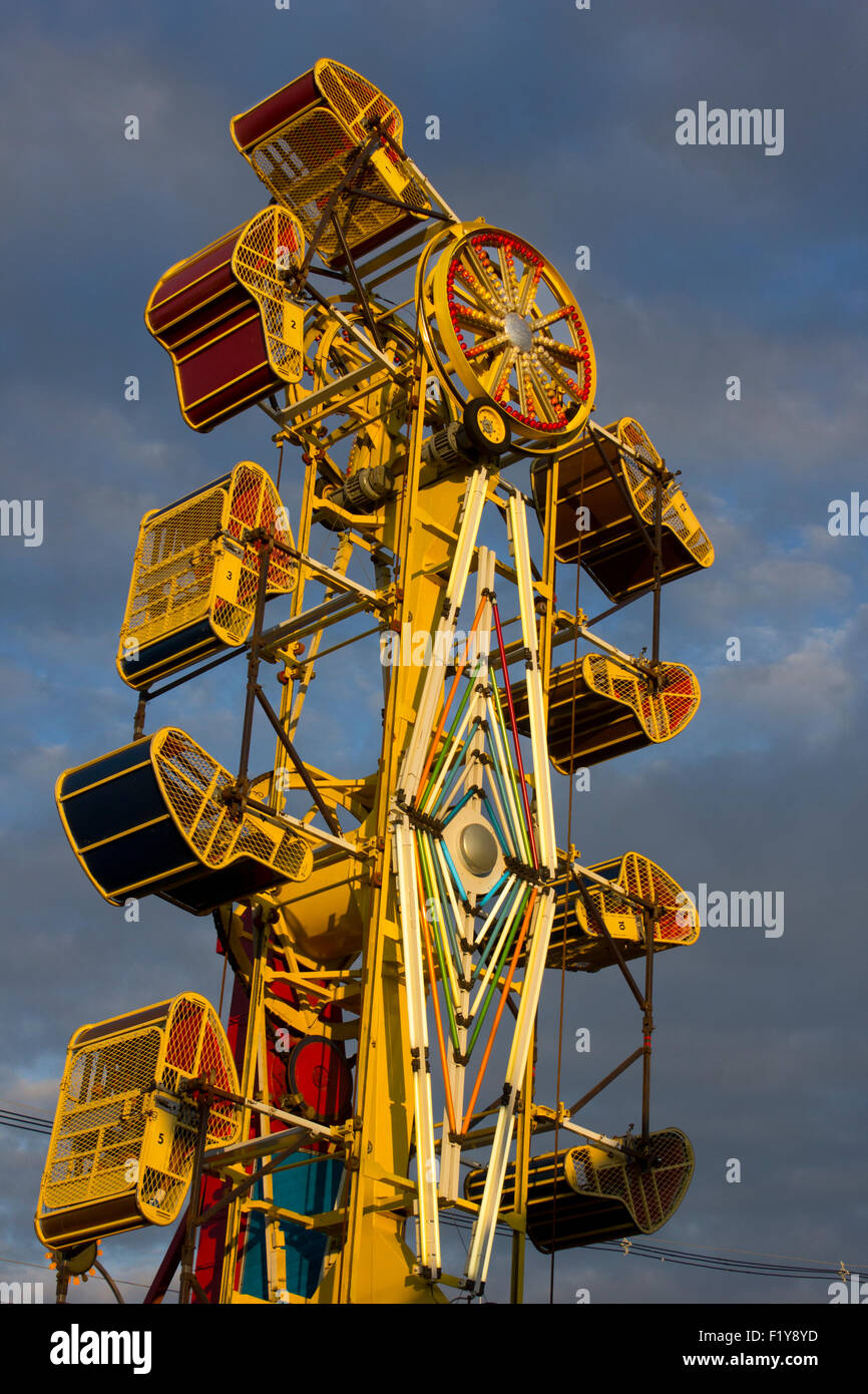 Tacky carnival ride contre un ciel menaçant. Banque D'Images