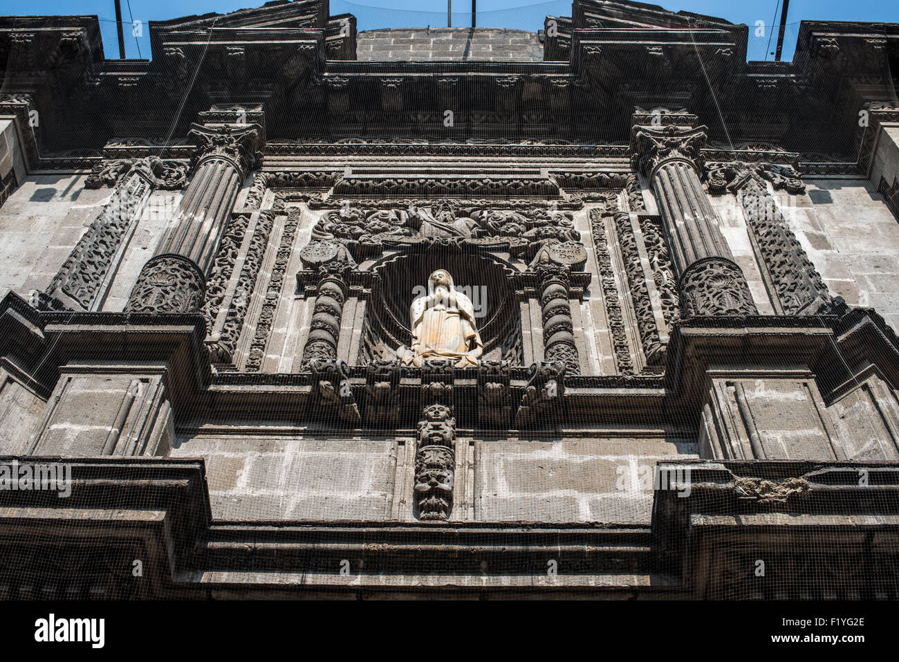 MEXICO, Mexique — des pierres coloniales ornées et une statue religieuse ornent la façade au-dessus de l'entrée de l'Iglesia de San Bernardino. L'église du XVIIe siècle illustre la décoration architecturale élaborée typique du style baroque mexicain. Ce bâtiment historique près de Zocalo à Mexico conserve ses éléments de façade coloniale d'origine. Les détails sculpturaux mettent en valeur les traditions sophistiquées de sculpture sur pierre de l'architecture religieuse coloniale. Banque D'Images