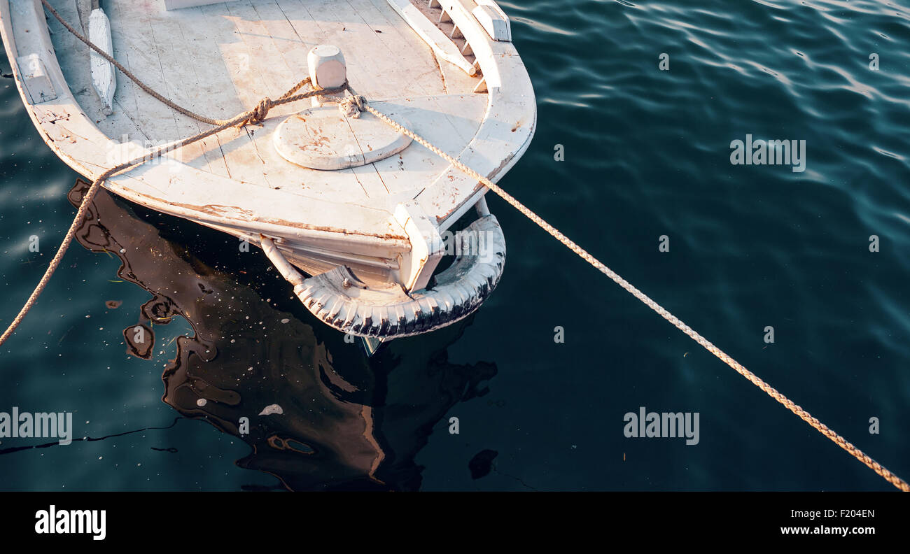Détails d'un bateau en bois blanc, bleu profond de l'eau tout autour. Banque D'Images