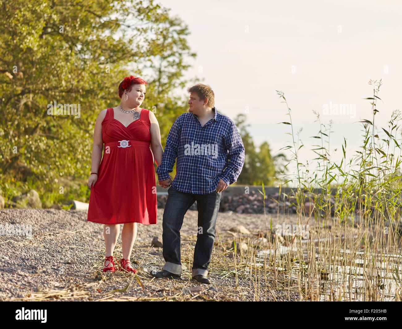 Quel beau couple marche sur le rivage, la lumière chaude soirée d'été Banque D'Images