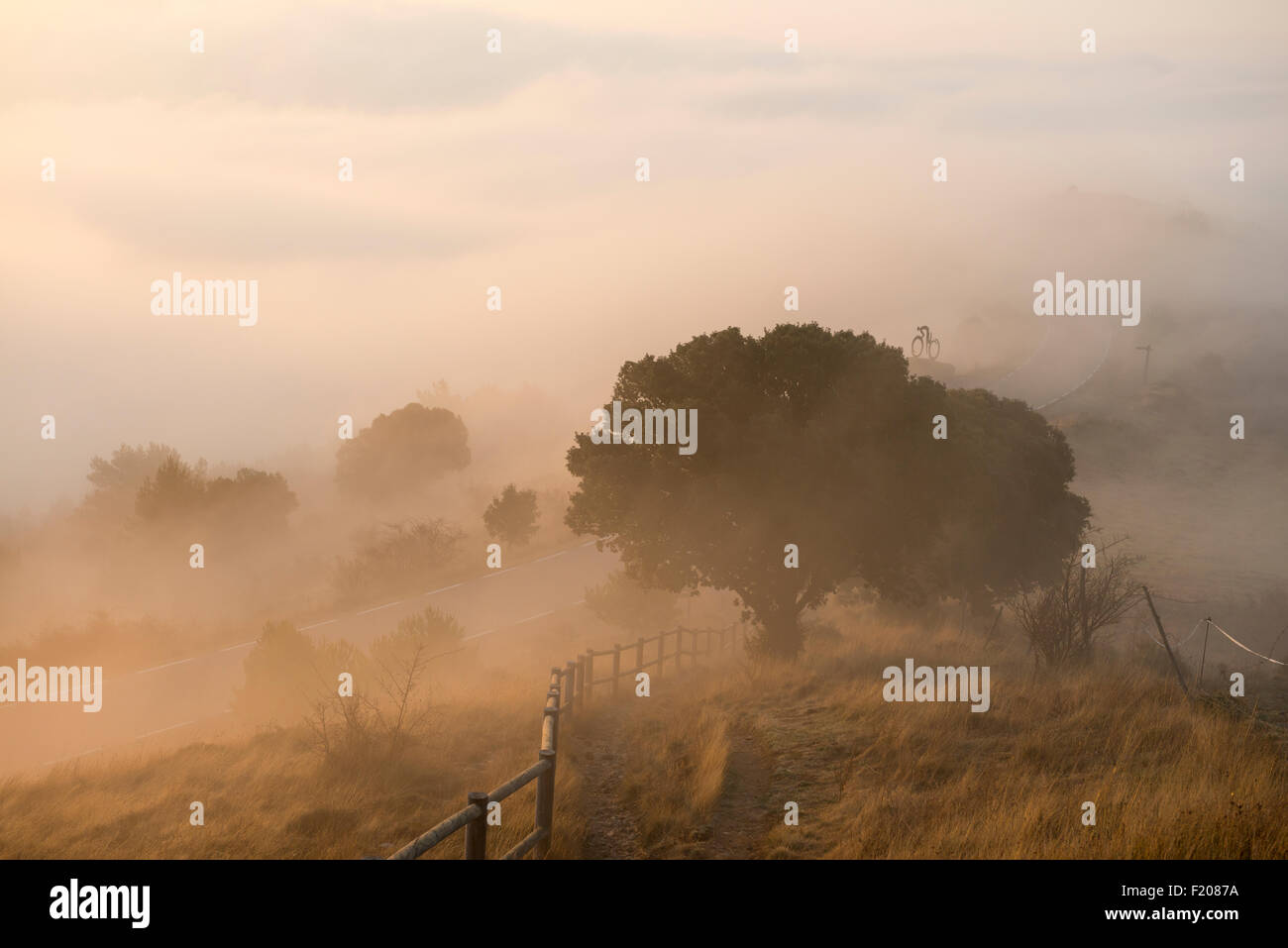 Lever du soleil paysage à Coll de Serra Seca dans le Pré-Pyrenees Catalan avec une lueur jaune dans la brume. Banque D'Images