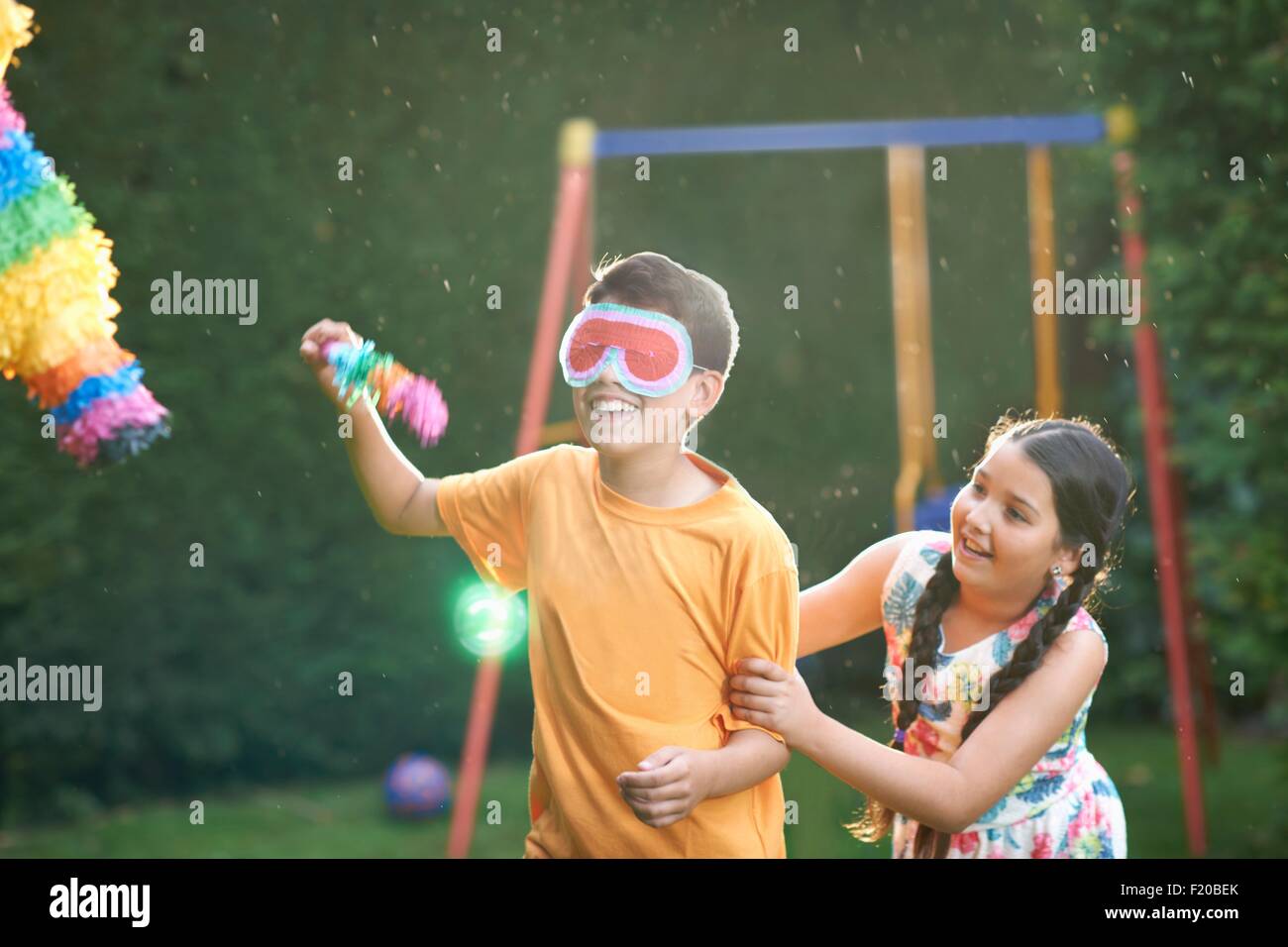 Enfants jouant dans le jardin de pinata Banque D'Images