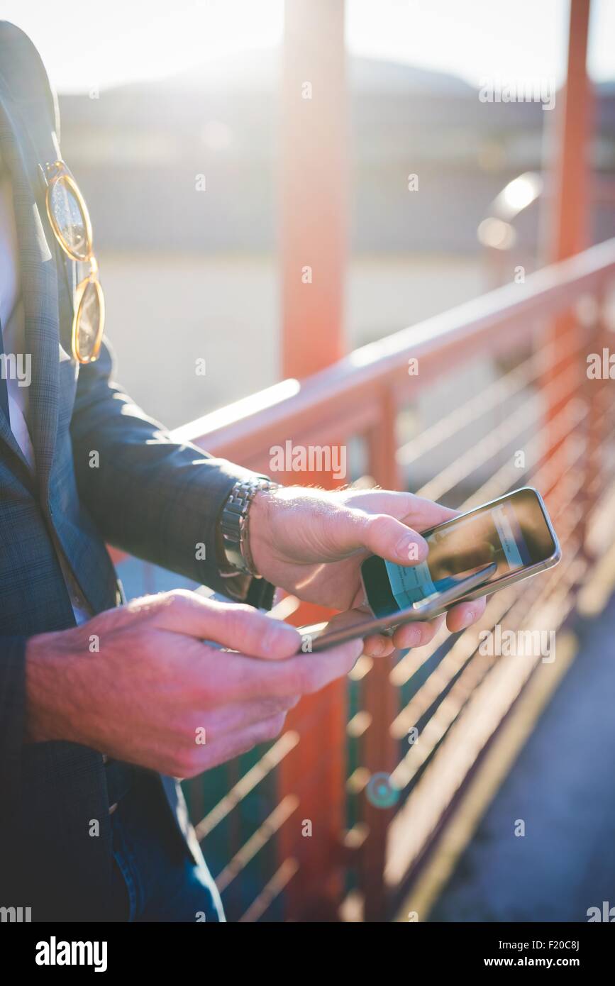 Close up Portrait of young mans hands using digital tablet et smartphone sur passerelle Banque D'Images