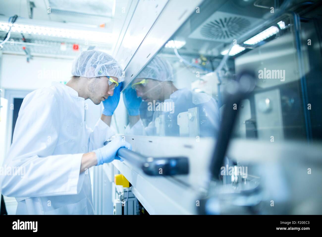 Male scientist monitoring hotte en salle blanche de laboratoire d'essai Banque D'Images