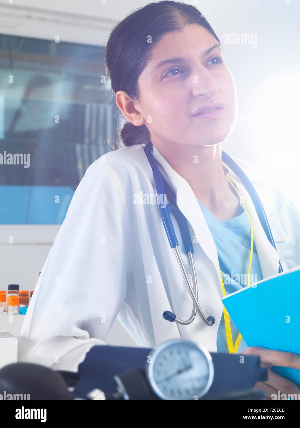 Femme médecin qui envisagent des notes médicales à l'hôpital Banque D'Images