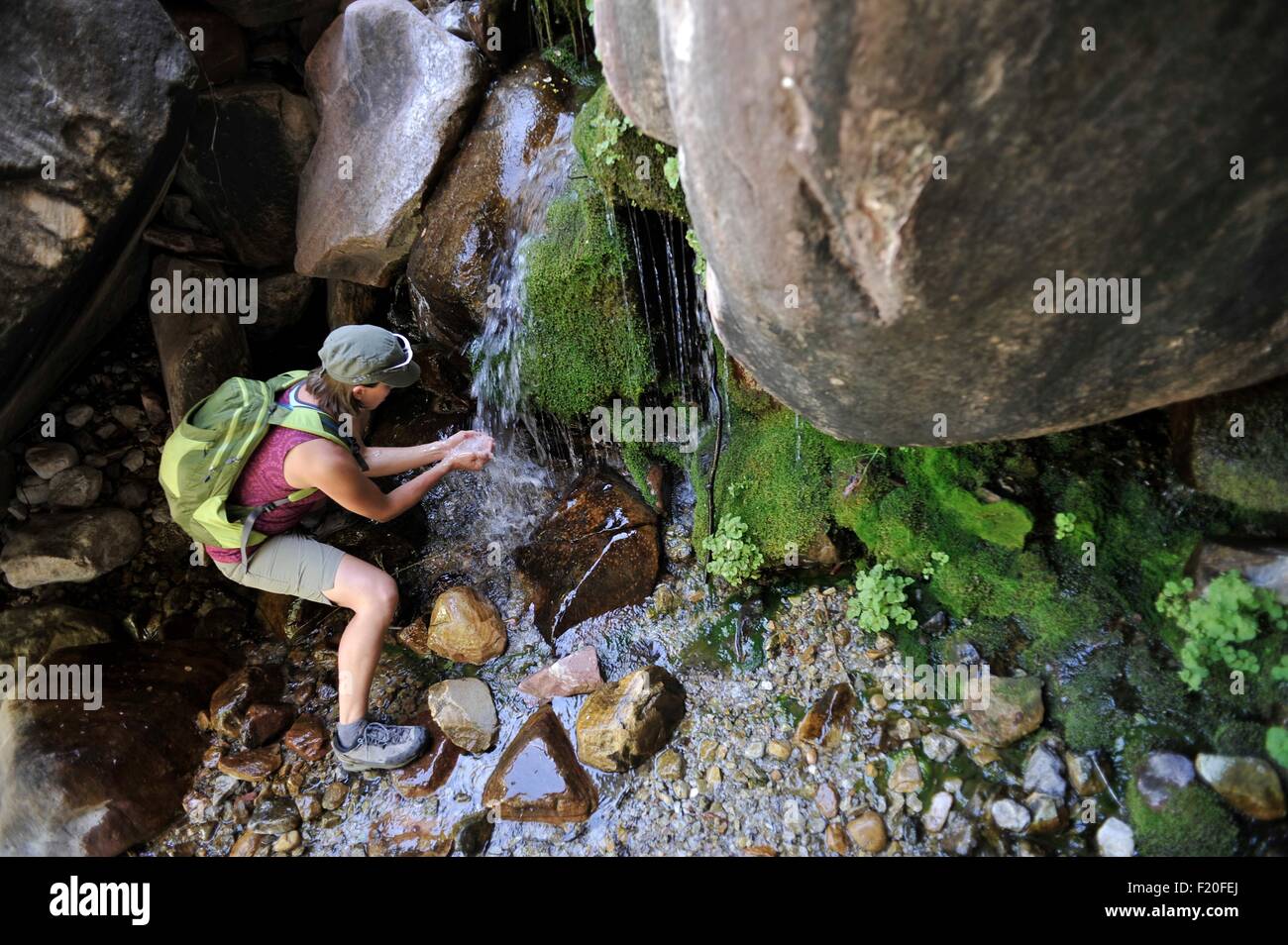 Randonneur de saigner les mains à la collecte de l'eau cascade Banque D'Images