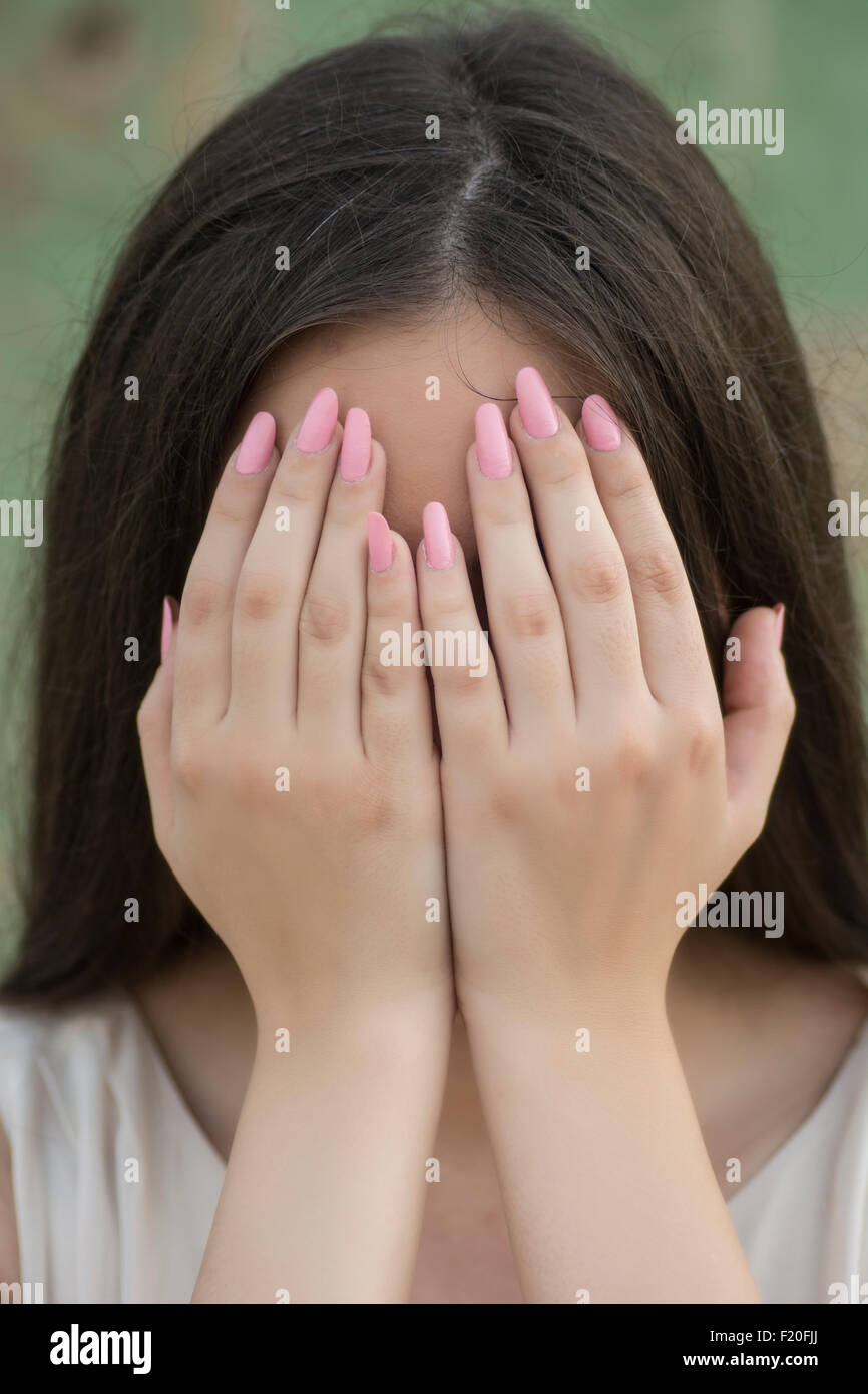 Femme peur de se cacher le visage avec les mains Banque D'Images