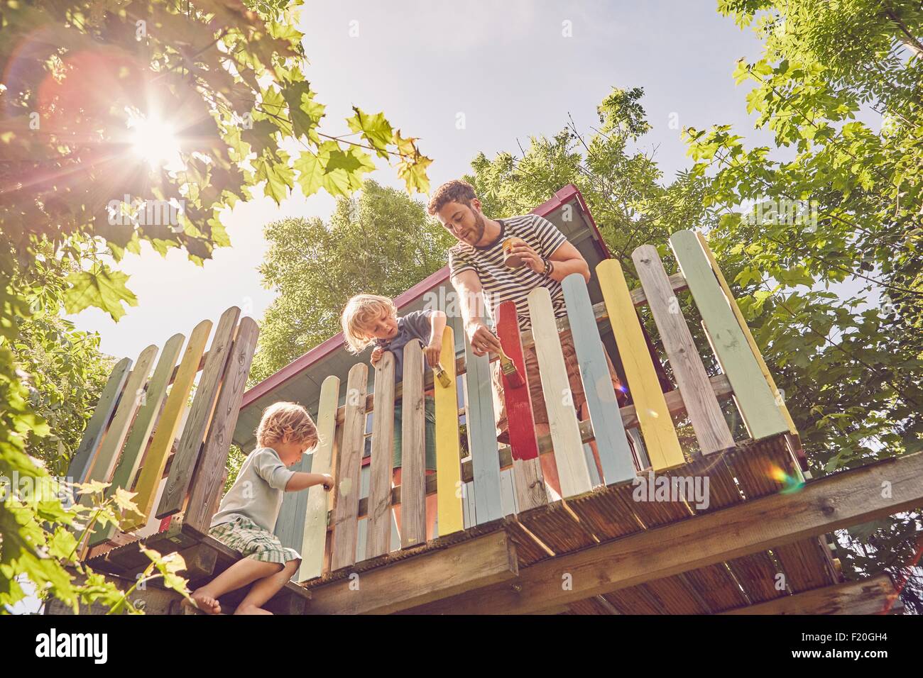 Son père et ses deux fils, peinture maison de l'arbre, low angle view Banque D'Images
