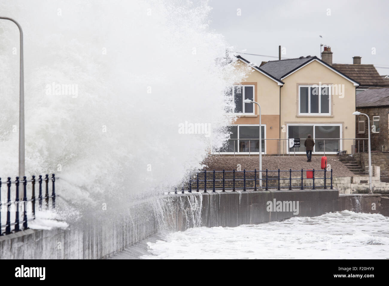 La marée haute frappant le port mer défenses dans la ville côtière de l'Amblève, Northumberland, England, UK Banque D'Images