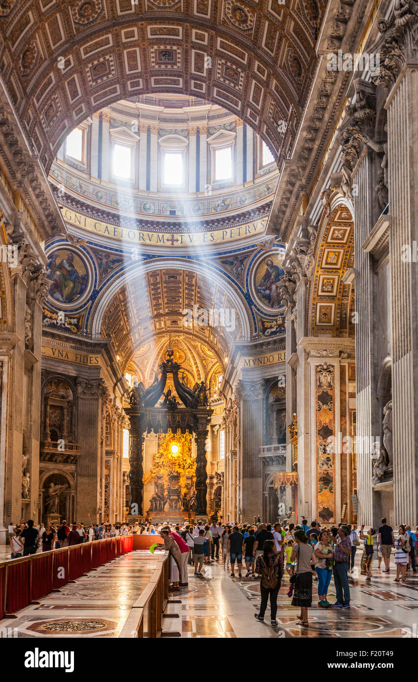 Les touristes et les visiteurs à l'intérieur de la Basilique St Pierre avec puits de lumière qui traverse l'intérieur de toit dome Rome Italie Europe de l'UE Banque D'Images