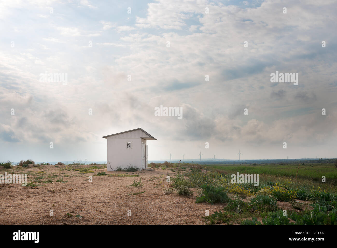 Paysage avec une petite maison blanche sur la plage avec des moulins Banque D'Images