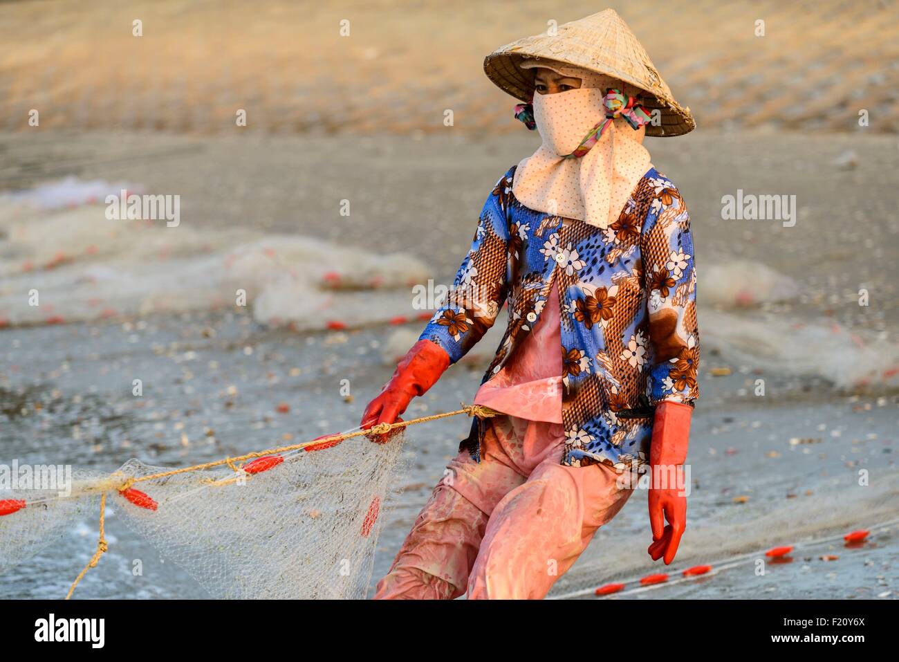 Vietnam, Mui Ne, le transport de filet de pêche sur la plage Banque D'Images