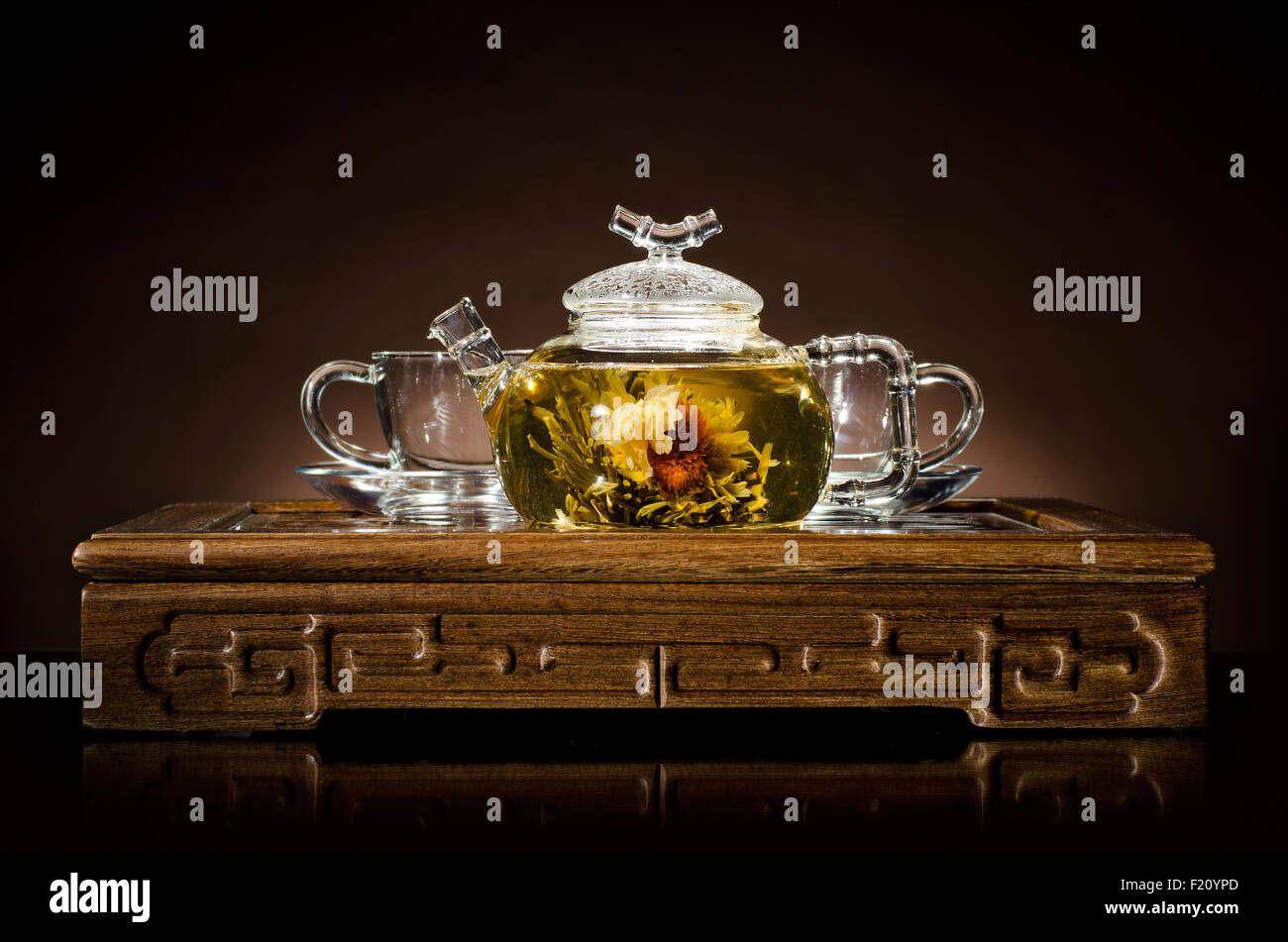Photo horizontale de la théière en verre avec du thé vert dans la tasse, sur le backgrpund brun, gros plan Banque D'Images