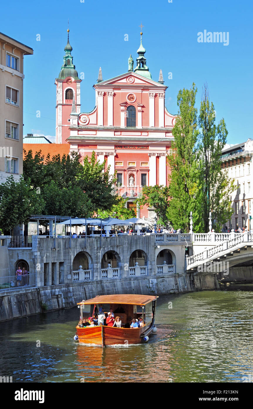 Ljubljana, Slovénie - septembre 7, 2015 - barque sur la rivière Ljubljanica Eglise Saint François avec en arrière-plan Banque D'Images