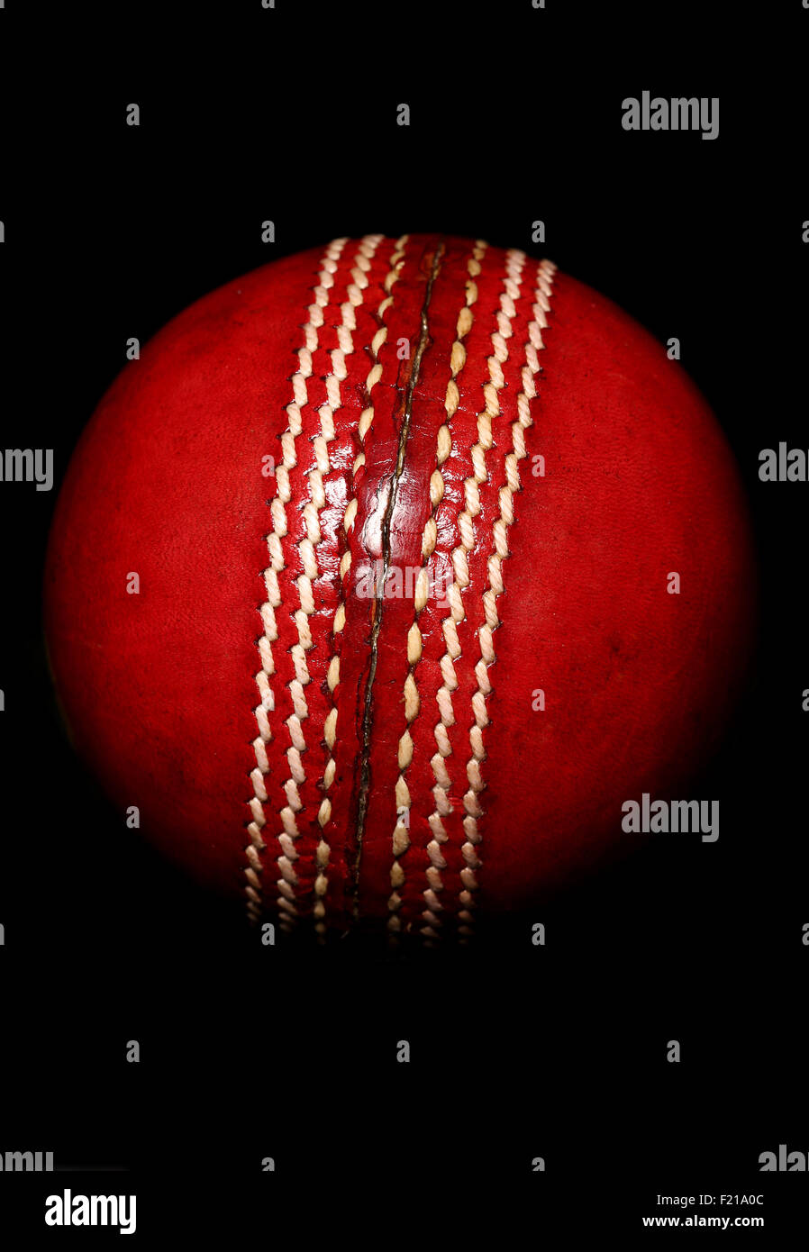 Cricket ball rouge sur fond noir Banque D'Images