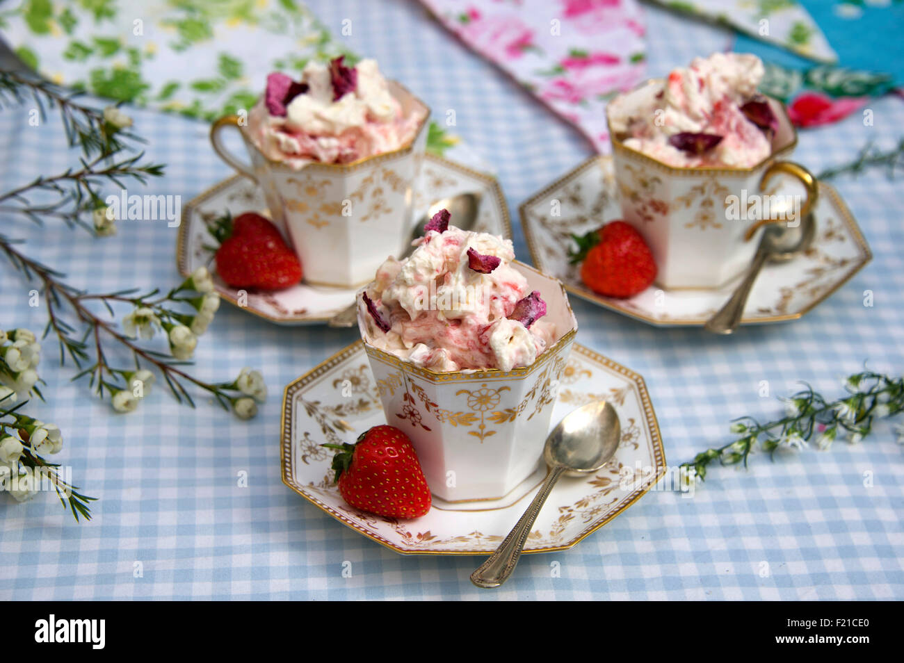 Eton Mess, un dessert traditionnel anglais fait avec de la meringue, crème, fraises et ici servi dans trois tasses en porcelaine a UK. Banque D'Images