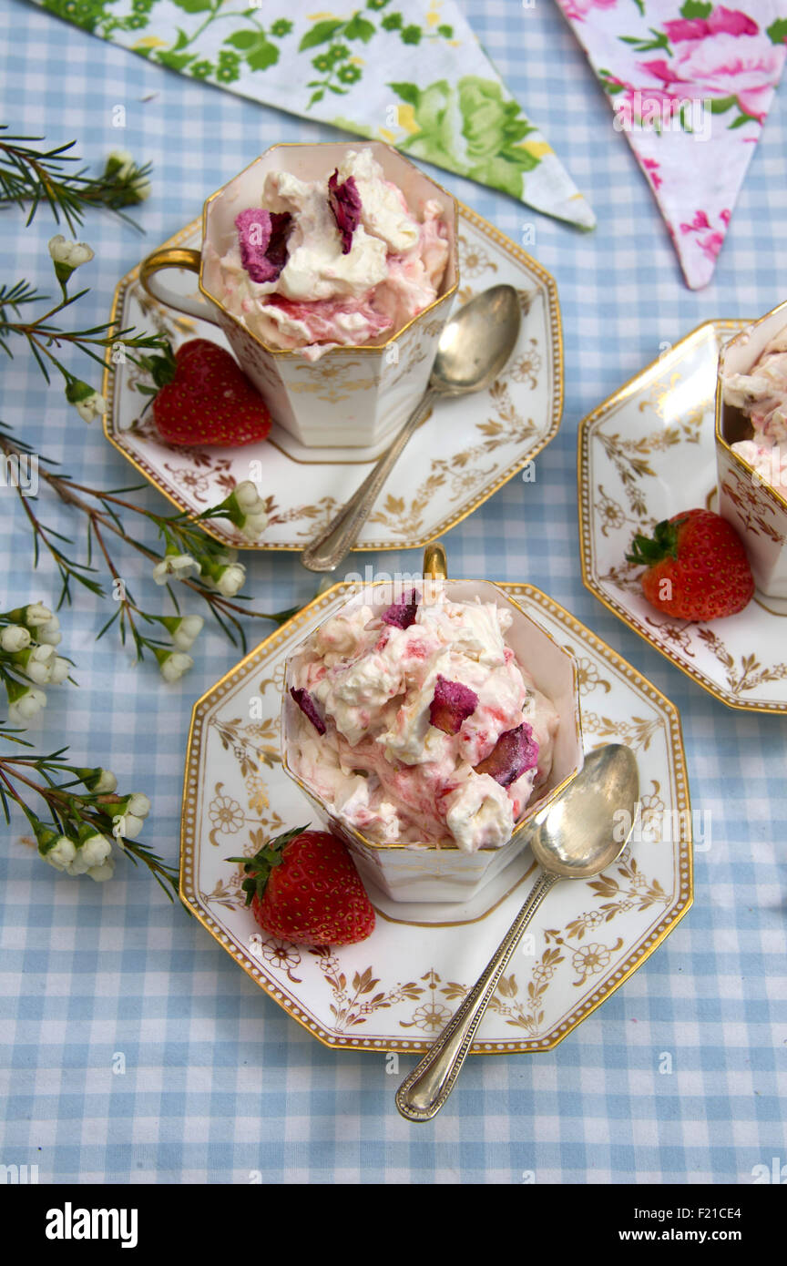 Eton Mess, un dessert traditionnel anglais fait avec de la meringue, crème, fraises et ici servi dans trois tasses en porcelaine a UK. Banque D'Images