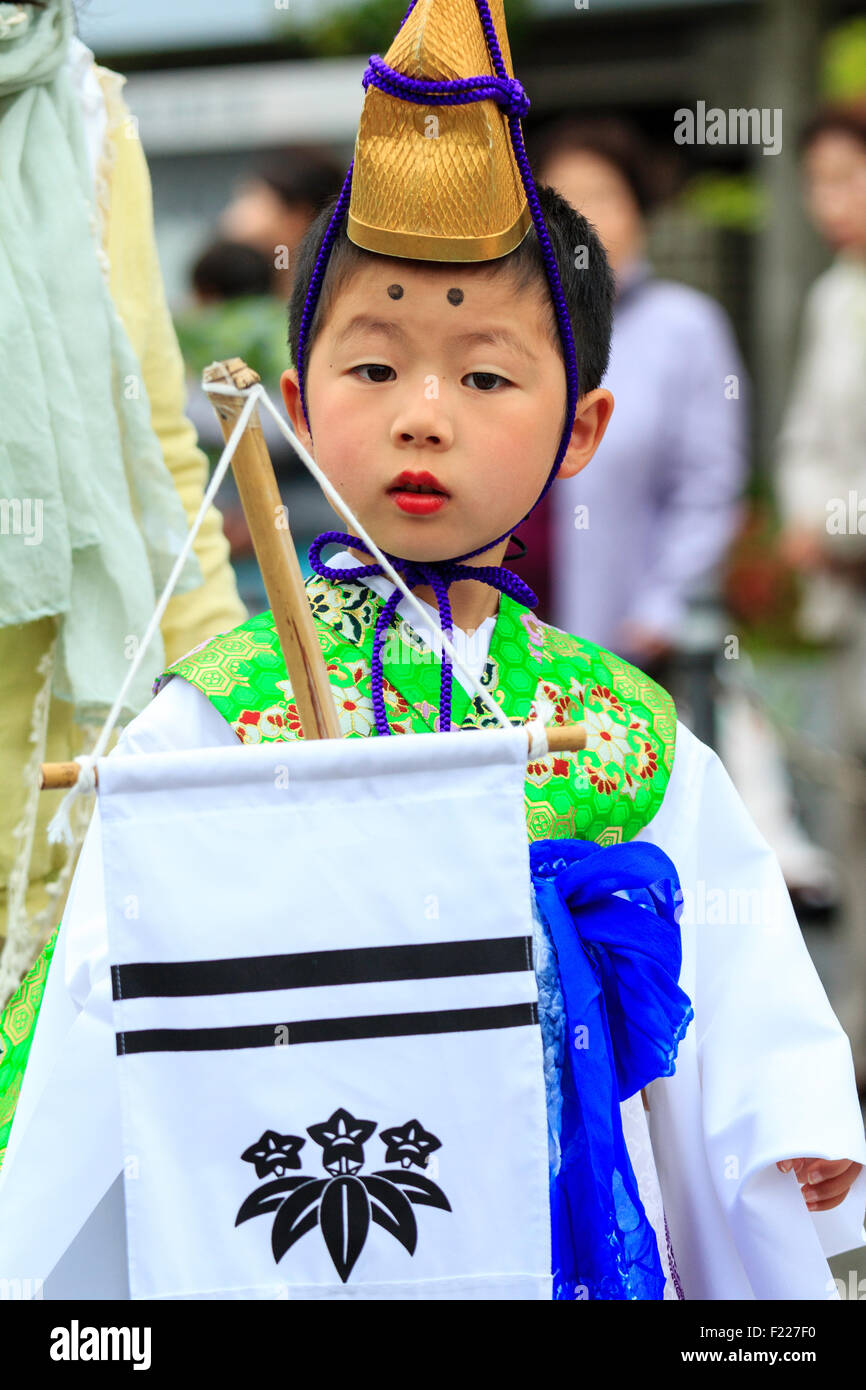 Genji Tada culte festival. Parade, garçon, 6-8 ans, habillés en costume d'époque Heian, avec de l'or, robe blanche et chapeau veste verte, dans les yeux. Banque D'Images