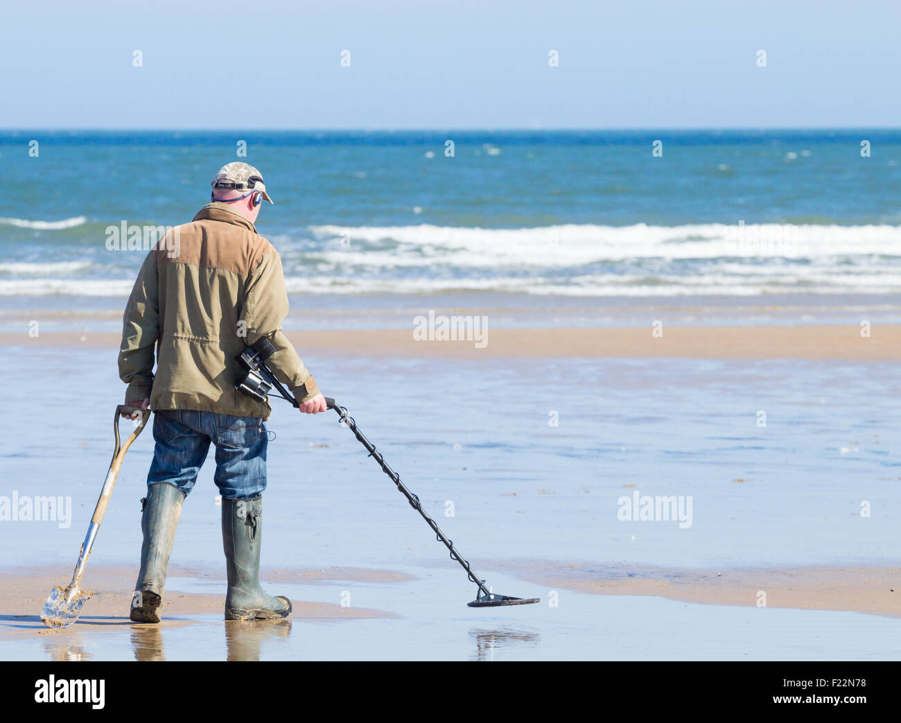 Homme Détection des métaux avec détecteur de métal sur la plage. UK Photo  Stock - Alamy