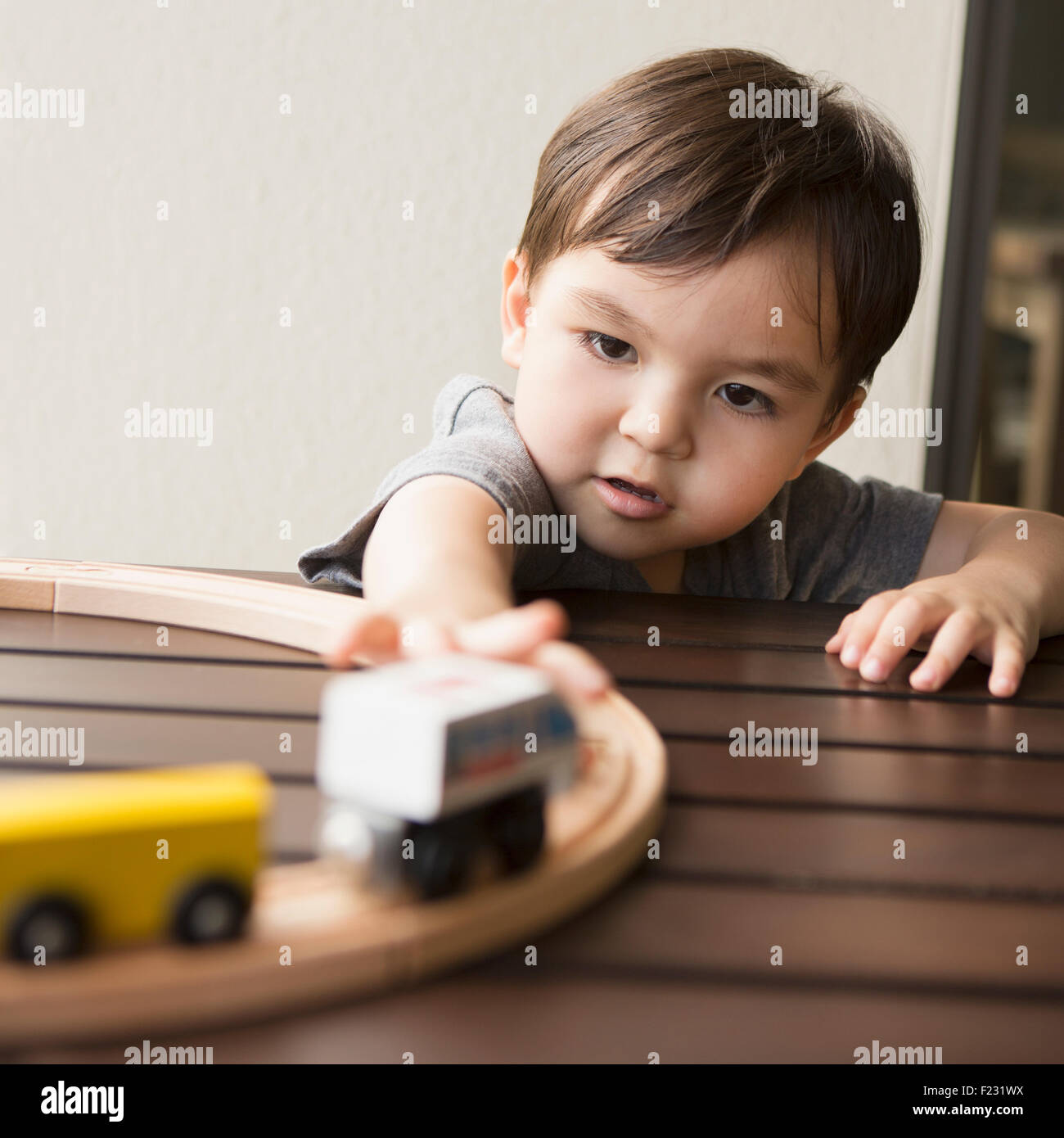 Jeune garçon jouant avec un train en bois. Banque D'Images